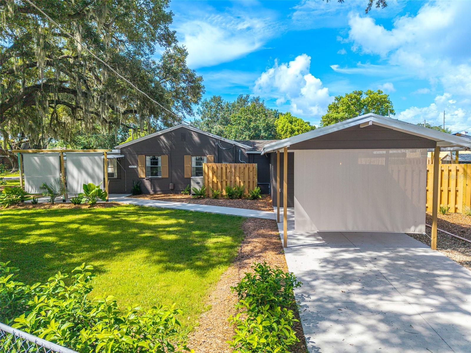 Welcome to your own slice of Florida paradise! Nestled on a FULLY FENCED CORNER LOT beneath a canopy of MATURE OAK TREES, this beautifully renovated cottage-style 3-bedroom, 1.5-bathroom block home is full of warmth, charm, and thoughtful updates throughout. Inside, you'll find an inviting living space that flows into a distinctive kitchen with industrial-rustic design elements, open wood shelving, distressed cabinetry, and BRAND-NEW APPLIANCES. The enclosed lanai, currently being used as a bedroom, provides a spacious and versatile flex space complete with an electric fireplace, making it ideal as a primary suite, guest room, home office, or additional living area. Step outside and discover the true heart of this home—a beautifully crafted new multi-level pool deck where you can enjoy peaceful LAKE VIEWS while you can soak up the sunshine, entertain family and friends, or unwind with your morning coffee. Surrounded by lush landscaping and towering oak trees, the backyard offers the cozy feel of a private cottage retreat. The property also features a LARGE METAL STORAGE SHED, an incredible edible garden with watermelon, dragon fruit, blueberries, bananas, tomatoes, and cucumbers, plus unique surfer-style swings hanging from the majestic oak trees in the front yard, adding even more charm and character. Best of all, this one-of-a-kind property is being sold FULLY FURNISHED (with only a few personal items excluded), making it truly move-in ready.

Ideally located just moments from LAKE LENA, you'll enjoy easy access to the public boat ramp, boating, fishing, kayaking, and scenic waterfront recreation. Downtown Auburndale, local restaurants, parks, shopping, schools, and the renowned Lake Myrtle Sports Complex are all just minutes away. With convenient access to US-92, the Polk Parkway, and I-4, commuting to Lakeland, Winter Haven, Orlando, and Tampa is effortless while still enjoying the peaceful charm of lakeside living.