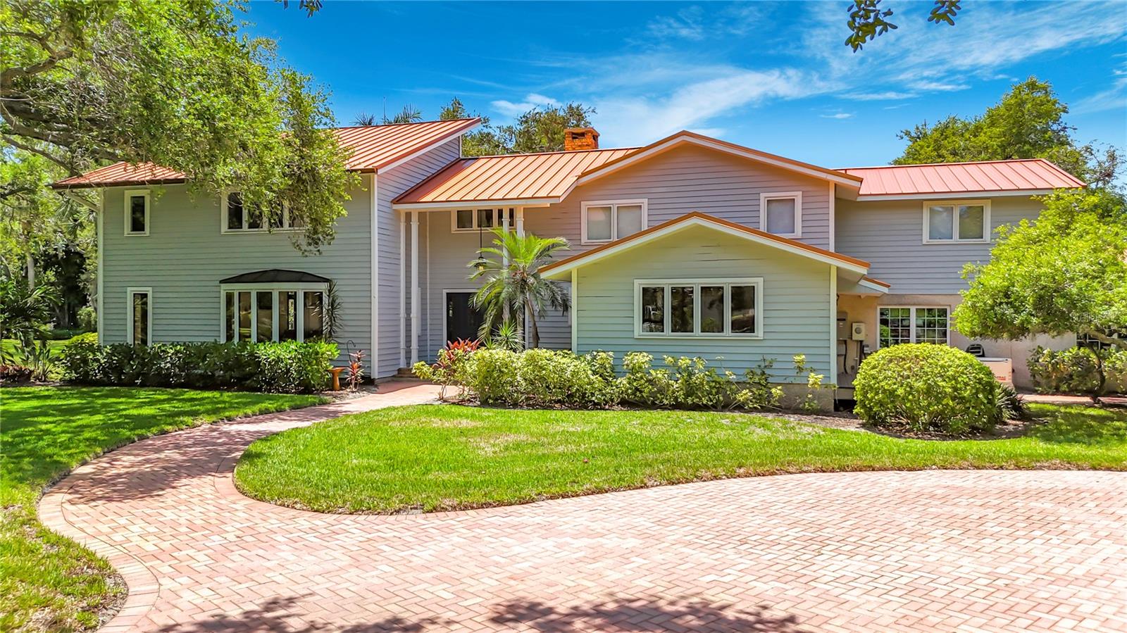 Presenting an exquisite 6-bedroom, 4-bathroom estate nestled quietly in the historic Palma Sola Park neighborhood. Interior highlights include multiple remodels over the last 10 years, a brand new metal roof, vaulted ceilings, skylights, a private office & study, and a game room with a second kitchen and wine cooler storage. Enjoy using top-of-the-line Wolf and Sub Zero appliances, and revel in the security of a full-size Generac generator on independent propane and an additional on-site well for irrigation. Savor the sun kissed opportunity to swim in the expansive  swimming pool and paver patio area, all beneath a brand new heavy-duty pool cage enclosure. This exceptional property also features a 4-car detached garage, a peaceful creek at the rear, and majestic old oak and fruit trees on property. Offering a harmonious blend of luxury, functionality, and natural beauty, making it a truly exceptional find in the prestigious bayfront neighborhood. Nestled under large oaks in the serene and coveted Palma Sola Park neighborhood in NW Bradenton, the location offers a peaceful retreat near the picturesque Palma Sola Bay. Just a short 10-minute drive away, the award-winning Manatee beaches beckon with their pristine sands and crystal-clear waters. This sought-after area provides a perfect balance of tranquility and coastal allure, making it an ideal location to suit a variety of active lifestyle preferences. Whether enjoying the calming bay views or basking in the sun-kissed beaches, this location embodies a blend of natural beauty, peaceful living and sought-after convenience.