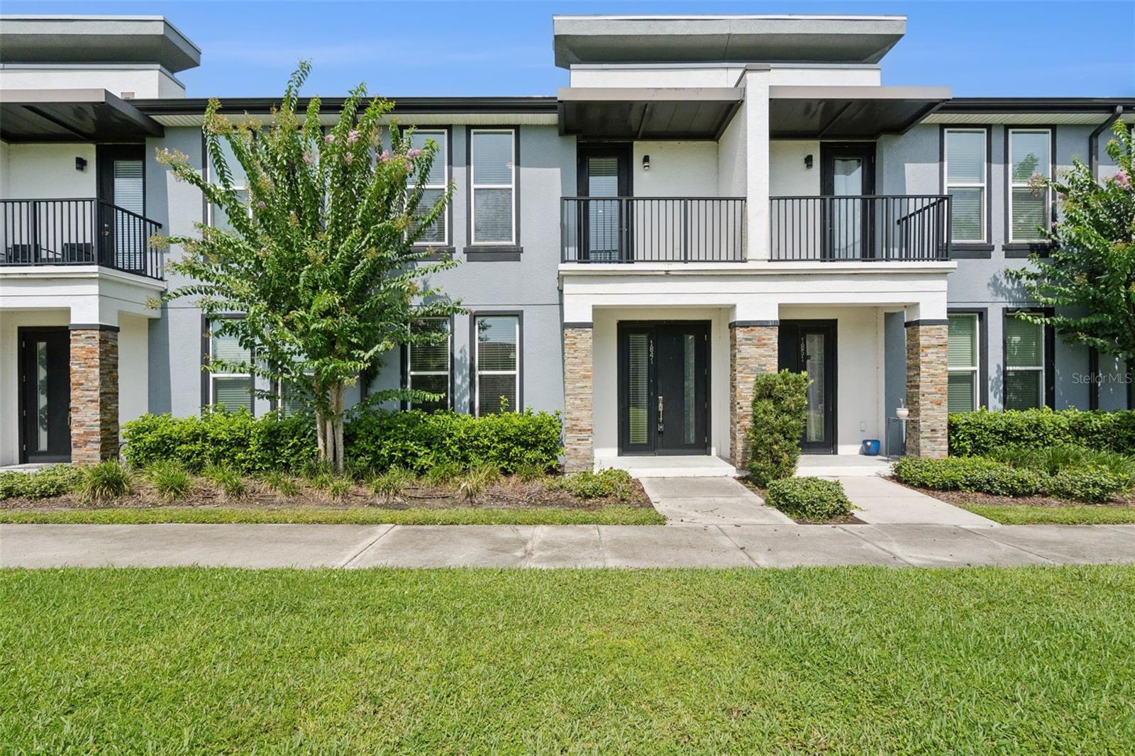Exceptional value meets modern style in this contemporary end-unit townhome in Kissimmee's SoHo at Lakeside, offering extra privacy, abundant natural light, and peaceful greenbelt views. To make your purchase even easier, the seller is offering $10,000 toward the buyer's closing costs and prepaid expenses. Designed with both style and functionality in mind, this home features 9-foot ceilings and an open-concept layout with wood-look flooring, creating a bright and inviting space for everyday living.
The open kitchen is a standout, showcasing quartz countertops, a spacious center island, sleek European-style cabinetry, designer lighting, and stainless steel appliances—perfect for entertaining or casual meals at home.
Upstairs, retreat to the spacious primary suite featuring a walk-in closet, a beautifully appointed en-suite bath, and a private balcony overlooking the trees and walking path—your own peaceful outdoor escape. Additional highlights include modern bathrooms, an in-unit washer and dryer, and a two-car garage.
Enjoy exceptional value with no CDD fees and an HOA that includes a community pool, exterior maintenance (including the roof), cable TV, high-speed internet/Wi-Fi, lawn care, and trash service.
Whether you're looking for a primary residence or a turnkey investment property, this home offers outstanding versatility in a sought-after location. Ideally situated just minutes from Orlando International Airport, Lake Nona's Medical City, shopping, dining, and major roadways, it delivers the perfect blend of modern design, low-maintenance living, and convenience.