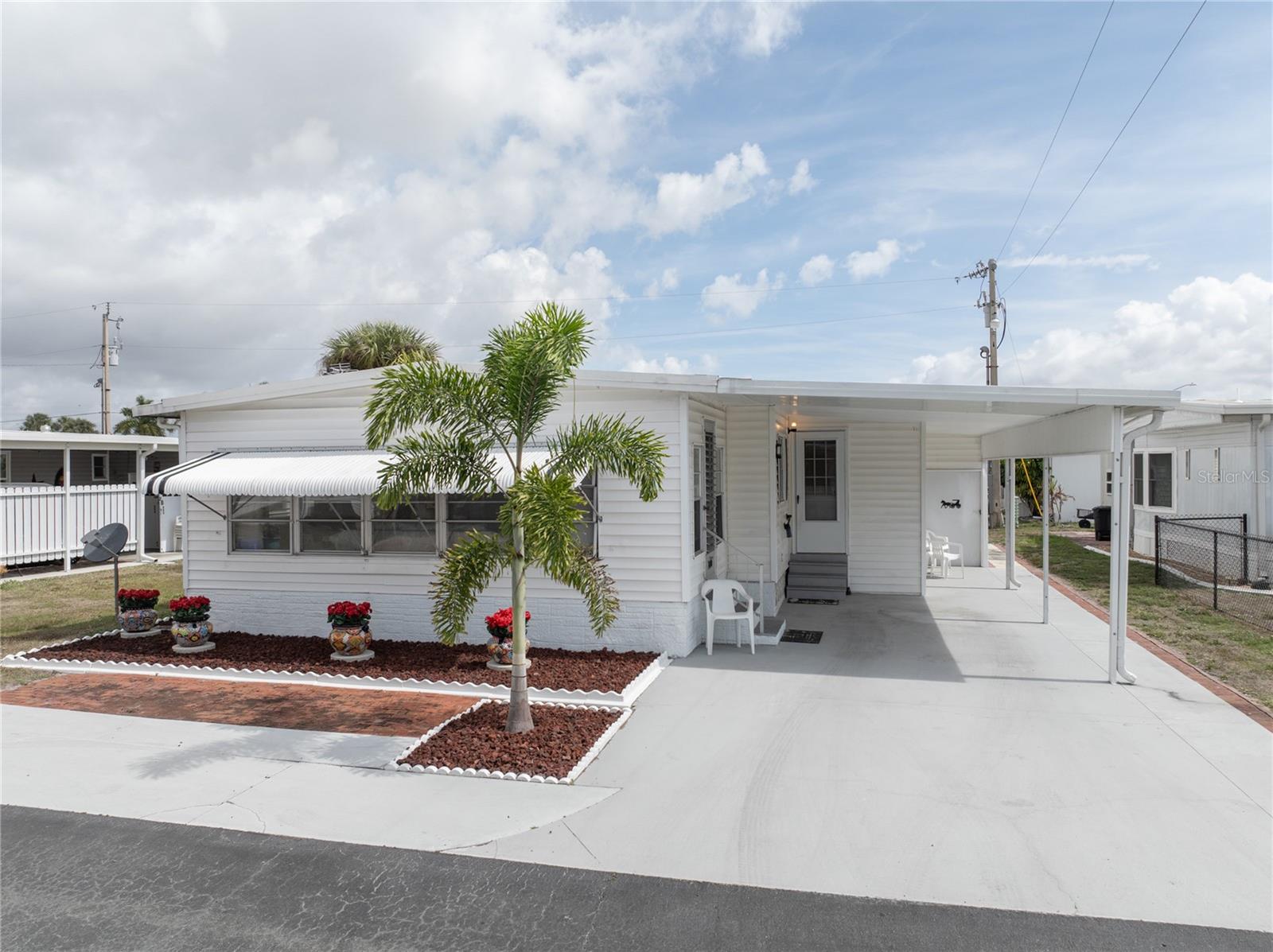 Welcome to relaxed Florida living in this beautifully maintained 2-bedroom, 2-bath manufactured home, located in a friendly and active 55+ community where comfort and lifestyle come together. Built in 1970 and thoughtfully cared for over the years, this home offers a warm and inviting interior with a functional layout designed for everyday ease. The living spaces feel open and comfortable, while the convenience of an indoor laundry area adds practical value that homeowners truly appreciate. Step outside and you’ll find features that make this property even more appealing. The covered carport provides protection from the Florida sun and weather, while the workshop/storage shed houses the lawnmower which conveys, offers the perfect space for tools, hobbies, projects, or additional storage. Set within a welcoming 55+ community, residents enjoy a peaceful environment along with opportunities to connect with neighbors and participate in community activities. Community activities include: dances, ceramics, yoga, card games, water aerobics and more. It’s the kind of place where mornings start slow, afternoons are spent enjoying the Florida sunshine, and neighbors quickly become friends. Whether you're looking to downsize, find a seasonal getaway, or secure an affordable full-time residence, this well-cared-for home offers comfort, practicality, and the easygoing Florida lifestyle so many folks are searching for. Opportunities like this don’t stay on the market long. Schedule your showing and see why this charming home is the perfect place to start your next chapter.