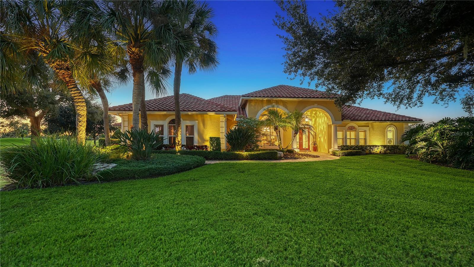 Set on a serene cul-de-sac within the prestigious Laurel Oak Estates, this custom-built residence captures the essence of Sarasota’s coveted golf-course lifestyle. Poised on nearly an acre with sweeping fairway and lake views, the home offers more than 5,100 square feet of beautifully designed living space enhanced by timeless architectural detail, modern functionality, and effortless indoor-outdoor flow.
A private winding drive and manicured landscaping introduce the stately façade, where double entry doors open to a grand foyer with high ceilings and walls of large windows that fill the interiors with natural light. The spacious living and dining areas feature custom built-ins and millwork, with expansive sliders framing sunset views of the sparkling pool and golf course beyond. Perfect for entertaining, the gourmet kitchen combines rich wood cabinetry with granite countertops, a large center island, double ovens, built-in refrigerator, wet bar area, and casual dining nook overlooking the fairway. The adjoining family room offers a warm gathering space anchored by solid wood built-ins and a gas fireplace, with seamless access to the screened lanai for alfresco living.
The primary suite is a private retreat with peaceful golf and water views, two custom walk-in closets, and a spa-inspired bath complete with soaking tub, separate shower, dual vanities, and private water closet. Three additional bedrooms, plus a fourth bedroom currently being used as den, provide ideal comfort for family and guests. The theater room is equipped with platform seating, custom cabinetry, 120” screen, surround sound, remote-controlled lighting, and 4K projector. A true highlight of the home is the second-floor bonus suite, currently used as an art studio, featuring vaulted tongue-and-groove ceiling, built-in desks, a full bathroom, and an expansive balcony capturing unforgettable sunset vistas across the course.
The screened outdoor living area defines the Florida lifestyle, showcasing a heated pool and spa, outdoor kitchen, and multiple seating areas for relaxing or entertaining. Mature landscaping, accent lighting, and the home’s ideal southwest exposure create a tranquil backdrop year-round. Additional features include plantation shutters, central vacuum, a three-car side-entry garage with golf-cart parking, and a whole-house solar system offering efficiency and peace of mind.
Nestled behind the gates of Laurel Oak Country Club, residents enjoy access to 36 championship holes of golf, tennis and pickleball courts, a junior Olympic pool, and a vibrant social calendar—all available with optional membership. Beyond the gates, you’re moments from Sarasota’s best amenities, including UTC Mall’s upscale shopping and dining, Nathan Benderson Park, and downtown Sarasota’s world-class arts, culture, and waterfront entertainment. Siesta Key and Lido Key beaches are within easy reach, completing the perfect blend of privacy, luxury, and convenience.
With its exquisite craftsmanship, prime location, and inspiring golf-course vistas, this Laurel Oak Estates residence delivers the ideal balance of sophistication and relaxed Sarasota living—an exceptional opportunity for those seeking elegance within one of the region’s most prestigious gated communities.