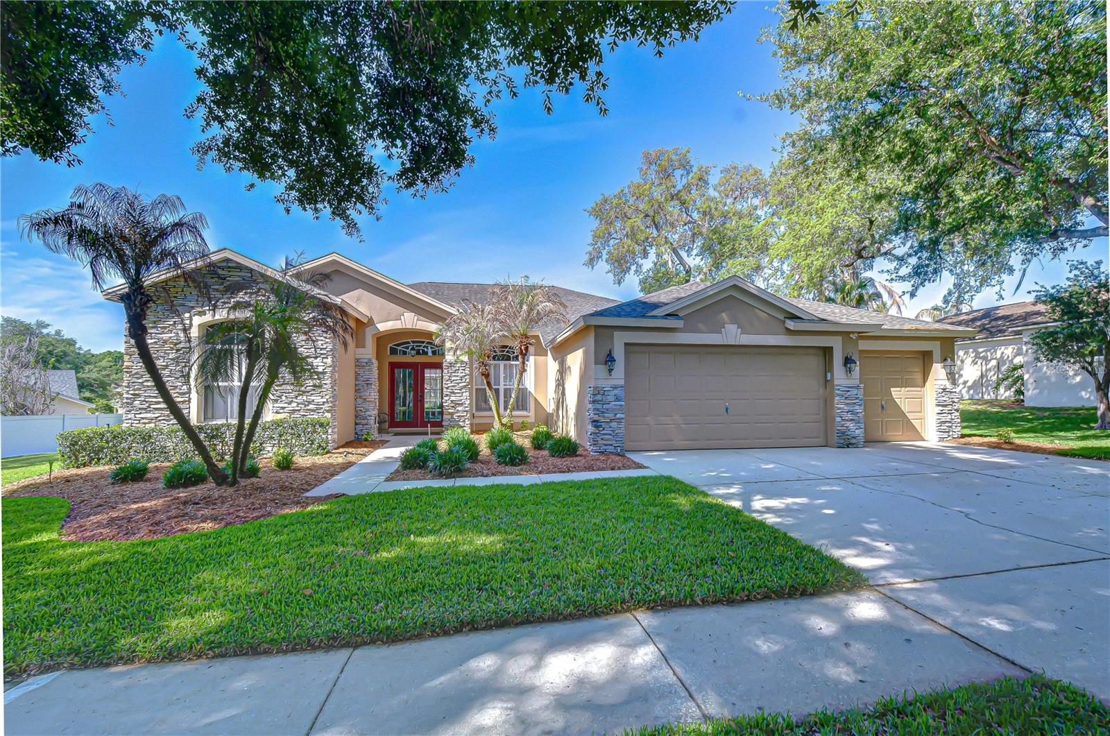 Nestled on an oversized homesite in the highly sought-after Bloomingdale community, this truly one-of-a-kind residence offers the perfect blend of elegance, comfort, and flexibility — all wrapped in exceptional pride of ownership. From the moment you arrive, the stunning curb appeal makes an unforgettable impression with lush professional landscaping, beautiful stone accents, and a meticulously maintained exterior that reflects years of thoughtful care and updates. Step inside to discover a light-filled open floor plan designed for both entertaining and everyday living. Formal living and dining rooms welcome guests with timeless charm, while expansive sliding glass doors frame breathtaking views of the sparkling pool and outdoor retreat beyond. A private home office with a closet offers the flexibility to serve as a fifth bedroom if desired. At the center of the home is a stunning upgraded kitchen that truly serves as the heart of the home. Thoughtfully updated with gorgeous white cabinetry, gleaming granite countertops, updated stainless appliances, and an oversized island with bar seating, this dream kitchen was designed for gathering. Overlooking the spacious family room and breakfast nook, the entire space feels open, bright, and connected, while multiple sliders throughout the main living areas flood the home with natural light and create seamless indoor-outdoor living. What truly makes this home rare is the incredible bonus living space tucked behind pocket sliders — offering the perfect in-law suite, multigenerational setup, or private guest retreat. Complete with its own full kitchen, living area, spacious bedroom, and full bath, this separate space provides endless possibilities while maintaining privacy and comfort. The thoughtfully designed split floor plan continues with three additional spacious bedrooms and two full bathrooms, while the luxurious primary suite is privately situated on its own side of the home. This serene retreat features a beautifully updated spa-like en-suite bathroom with upgraded sinks, countertops, lighting, added cabinetry, and two walk-in closets. Step outside and discover another favorite gathering space — the fully screened lanai overlooking the gorgeous pool and spa. Recently enhanced with PebbleTec resurfacing, decorative glass tile accents, resurfaced decking, and added handrails, this outdoor oasis feels like your own private resort. Beyond the pool, the lush backyard offers plenty of room to relax, entertain, or cultivate your dream garden filled with fruits, vegetables, herbs, and flowers. This home has been lovingly maintained and extensively improved over the years, including a new roof and both AC units replaced in 2016, professional exterior painting in 2018, updated interior paint throughout the main living areas, laundry room, office, trim, and doors, newer carpeting with transferable warranty, updated lanai screens and doors, replaced water heater in 2025, updated plumbing valves, refreshed garage walls, water softener improvements, and numerous additional enhancements throughout. From major system updates to cosmetic improvements, every detail reflects the care and investment poured into this exceptional property. Rarely does a home offer this level of beauty, functionality, flexibility, and meticulous maintenance all in one.