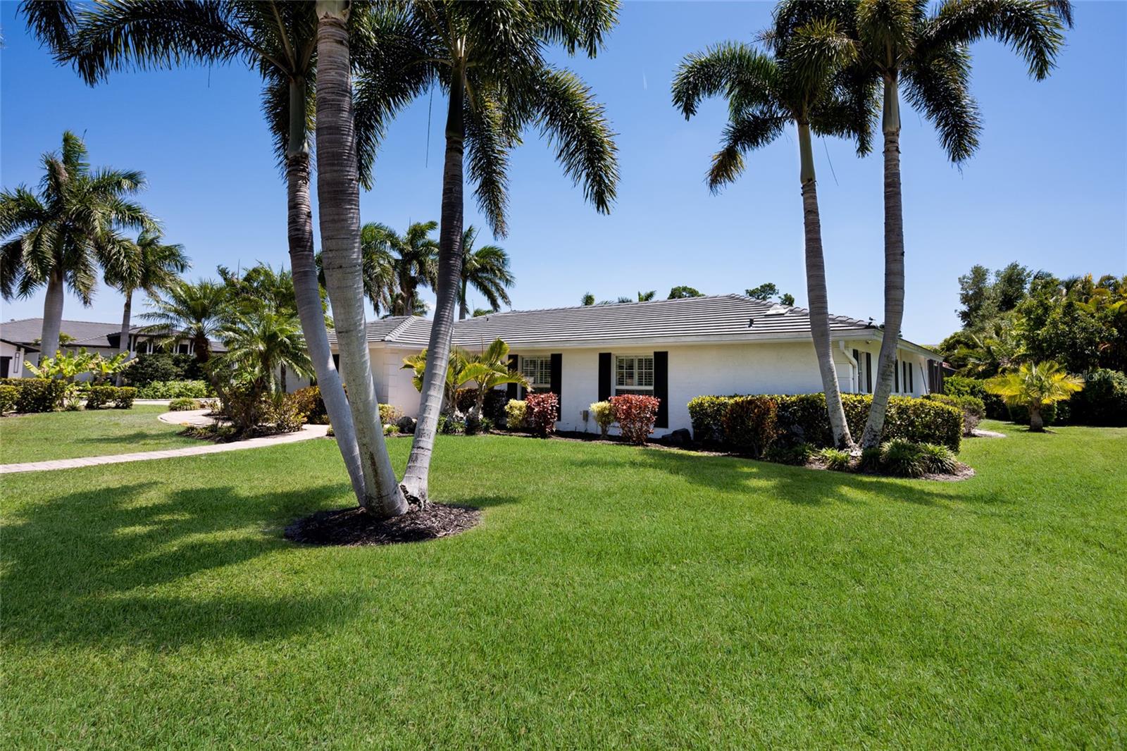 This tastefully updated and remodeled single story home is ideally located within the sought after Bird Key neighborhood. Set on a large corner lot, it features a clean, contemporary style that feels both current and easy to live in. The home offers three bedrooms, two and a half bathrooms, and a two car garage, creating a comfortable and well balanced living environment. Inside, the open concept split floor plan provides both flow and definition, with separate living and family rooms suited to modern living. The remodeled kitchen features quartz countertops and sleek contemporary cabinetry and is centrally positioned to connect the main living, dining, and family spaces.
Both living areas open through impact sliding glass doors to the lanai and pool, creating an easy transition between indoor and outdoor living. Fully opening sliders from the living and family rooms extend the space onto the pool deck, making the home particularly well suited for entertaining. The primary suite includes a spacious bedroom, walk in closet, and an updated en suite bathroom. Two additional guest bedrooms and a bathroom are located on the opposite side of the home, offering privacy for family and guests. The generously sized family room easily incorporates a small home office area. Recent improvements include a new tile roof in 2025, whole house propane generator 2025, a newer air conditioning system in 2023, and impact windows for added security and peace of mind. Bird Key offers one of Sarasota’s most desirable locations, just minutes from downtown Sarasota, St. Armands Circle, and Lido Beach. Residents also benefit from the nearby Bird Key Yacht Club, currently undergoing a full redevelopment and expected to reopen early in 2027 as a premier destination for boating, tennis, and social activities. PLEASE NOTE FRONT DOOR ENTRY IS LOCATED ON BOBWHITE WAY.