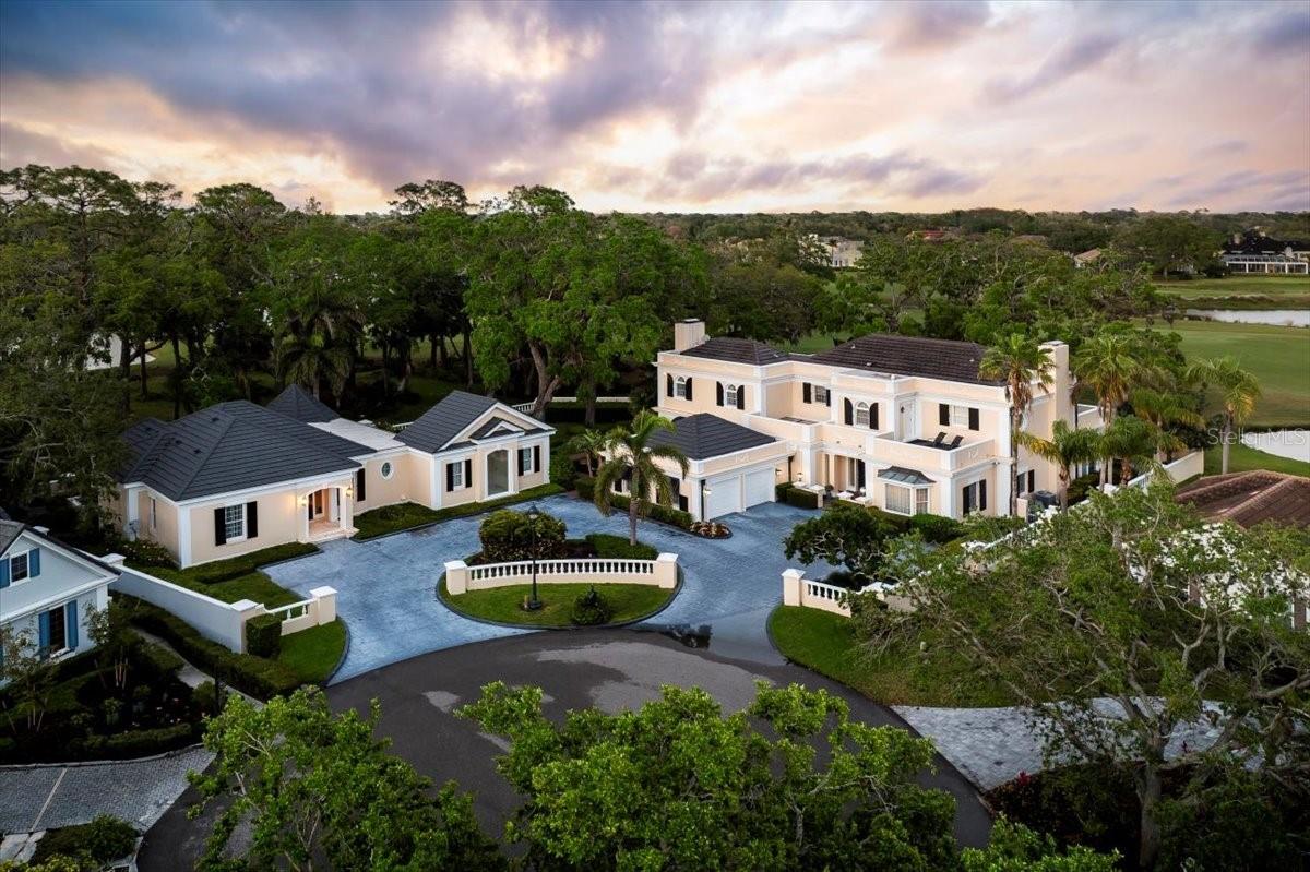Multigenerational living behind the gates of The Oaks Golf & Country Club. Set on a rare double lot at the end of a quiet cul-de-sac, this exceptional home is perfectly positioned on the 1st hole of the Heron Course, capturing sweeping golf course and clubhouse views—just minutes from Siesta Beach and Casey Key.

The main residence offers 4,700+ square feet, complemented by a private 1,500+ square foot guest house—ideal for extended family or long-term guests. Outdoor living is elevated with a pool and spa, outdoor kitchen, private guest laundry, and some of the most captivating views in the community.

At The Oaks, coastal sophistication unfolds across 36 championship fairways, tennis and pickleball courts, with endless opportunities for recreation, dining, and connection. Membership required.