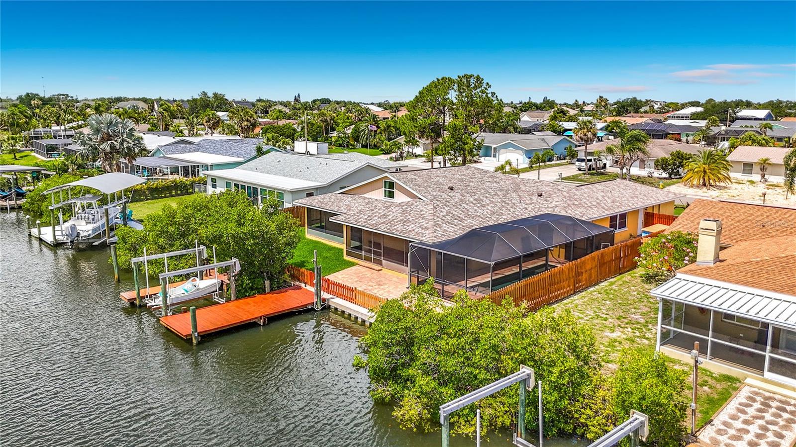 WATERFRONT POOL HOME with a PRIVATE DOCK and ALUMINUM BOAT LIFT (10,000lb capacity)! Welcome to Sabal Key in Apollo Beach, one of Tampa Bay's most coveted waterfront enclaves, offering a coastal lifestyle without an HOA or CDD. Wake up, walk out, and you're overlooking a deep-water canal that directly accesses the Tampa Bay and Florida Gulf Coast. Perfect for outdoor enthusiasts that enjoy fishing, kayaking, paddleboarding, and boating. While the location of this property is impressive with easy access to nearby amenities and major roadways, the home itself boasts just under 3000sqft of flexible space inside. Thoughtfully crafted with an array of features that cater to modern lifestyles while maintaining its original charm.
The upgraded kitchen or as some would call it - the "heart of the home" overlooks a spacious living room, creating a seamless flow for everyday living and entertaining. Ample eating space from island seating, a dinette space, and a formal dining room.
The split floor plan provides privacy and functionality, featuring not one, but two primary bedrooms – a rare and highly desirable layout perfect for multi-generational families, guests, and those who work from home. A spacious, second story loft with its own half bath adds another dimension to this home's flexibility, along with the downstairs bonus room that can be utilized as an office or den.
Let's talk exterior. There's a pool, a saltwater pool with a sleek design. The low-maintenance saltwater system offers a gentler swimming experience while reducing chemical usage. Brick paver hardscaping that elevates the outdoor aesthetic. This expansive covered area provides the perfect setting to host or relax. Parking will be a breeze with a two-car garage and oversized driveway that extends into the gated side yard; great for additional, secured boat or RV storage.