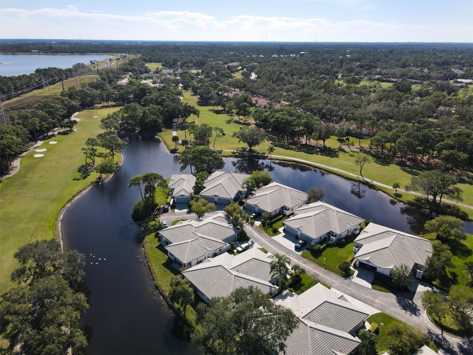 Price reduction! Privacy is delivered in this 2 bedroom, 2 bathroom villa, located near the end of a cul-de-sac in Long Common in The Meadows. Beginning with the newer paver driveway and sidewalk leading to the private gated courtyard, this villa lives like a single-family home, without all that exterior maintenance to worry about! Enter through the screened vestibule to find high 10-foot ceilings topped off with crown molding leading to a knock-out view through the lanai sliders to stunning long water and golf course vistas. The kitchen has an open pass-through to enjoy those beautiful views while prepping meals or enjoying breakfast at the eat in area. The original dome kitchen light has been removed and updated ceiling and new lighting just installed.  The living room and dining room are light-filled and spacious for entertaining. The split plan bedrooms allow for privacy when hosting guests. The primary bedroom has sliders to the lanai, lush greenery and water views, a very large walk in closet with organizers, linen closet and ensuite bathroom with step in shower. The guest bedroom enjoys close proximity to the guest bath with shower/tub combo. A roomy inside laundry room with full size washer and dryer also provides extra storage space. The two car garage provides room for the vehicles, bikes and pool toys and has a new overhead garage door opener. This villa has had all of the plumbing repiped for peace of mind. The community pool at the front entrance to Long Common provides a lovely heated pool and pool baths. This is a great place for a cooling dip in the pool or meet up with friends and neighbors for a libation during happy hour. Tile roof is maintained by the homeowner's association and is 12 years old. Water heater 2013. HVAC 2004 with regular bi-annual maintenance and a UV light. The sliding glass doors on the lanai were just serviced with new rollers installed. The Meadows offers 24 hour security patrol for peace of mind, an oasis of walking and biking trails, private dog park, pay-to-play golf, 15 lighted Har Tru tennis courts, Jr. Olympic pool and spa, pickleball and basketball courts and a new Lifestyle and Fitness center for all residents. Minutes to neighboring University Town Center Mall for luxury shopping and dining, Nathan Benderson Park for endless recreational and water activities, a short drive to downtown Sarasota for culture and the arts, and the powder sand beaches of the Gulf of Mexico. Live the laid back Florida lifestyle in The Meadows!