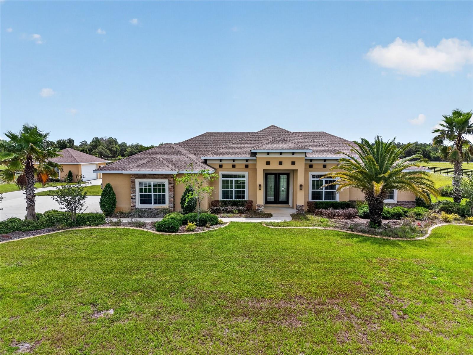 One or more photo(s) has been virtually staged. Looking for an established residential community with acreage and a well-designed home?  Welcome to the lovely Reserve at Lake Seneca in east Eustis, situated among country estates, farms, and established forests. This gated community offers residents access to idyllic Lake Seneca for boating, fishing, or just enjoying a serene view of this 95-acre private lake.  The 4.08-acre homesite (all high and dry) enjoys a fenced lot with a remote driveway gate, and a driveway alarm to notify the homeowner when vehicles are entering the driveway. Bring your vehicle collection or hobbies – there’s ample garage storage with an attached 3-car garage and detached 2-car garage (25'x28') - equipped with 40-amp electric service, a wi-fi garage door opener, and wired ethernet for streaming your devices. A custom saltwater pool was thoughtfully designed with a 40’ swim lane, LED multi-color pool lights, automated pool cleaner, and the heat pump for both heating and cooling the pool.  As you enter the home, beautiful sightline views of the pool and back of the property. The pool deck and lanai are screen enclosed so you can enjoy as much time as you like outside!  Easy care luxury vinyl plank floors throughout the living areas connect spaces through the foyer, dining room, living room, breakfast nook and kitchen.  Meal preparation, cooking and entertaining are effortless with a KitchenAid® convection oven, microwave, and induction cooktop.  Rich granite countertops and Wellborn® soft close cabinetry add a touch of sophistication to the space, and a walk-in pantry keeps items neatly organized. Enjoy coffee or quick meals in the breakfast nook that overlooks the pool – or watch the rocket launches to the east!  The primary suite affords privacy, a generous sized ensuite bathroom with raised dual vanities, soaking tub, walk-in tiled shower with a bench and niche to keep items tidy, and a 5’ x 10’ walk-in closet that is big enough to share.  The living room can accommodate your furniture collection and has sliding glass doors out to the lanai create an indoor/outdoor feel on ideal days.  A home office is located off the living room and has double glass doors and views of the front yard.  Two bedrooms and full bath adjacent to the office have a pocket door to create privacy if desired.  On the opposite side of the home, the 4th bedroom has the 3rd full bathroom which is ensuite with a tiled walk-in shower and serves as the pool bath with access to the lanai.  This home does not disappoint with multiple storage closets, an interior laundry room fitted with a utility sink, washer, and dryer.  Enjoy efficiency with a 9-zone wi-fi controlled irrigation system, private well with a 2025 treatment system, septic, and fiber-optic service for internet and tv provided in the community HOA fees.  The Reserve at Lake Seneca is also horse friendly! Grocery shopping is just 10 minutes away, dining, entertainment and shopping in nearby historic Mount Dora or Sanford are just a short drive.   Major airports and theme parks are within an hour via the Wekiva Parkway.  35542 Seneca Reserve Drive is ready to be enjoyed – are you ready for your next address?