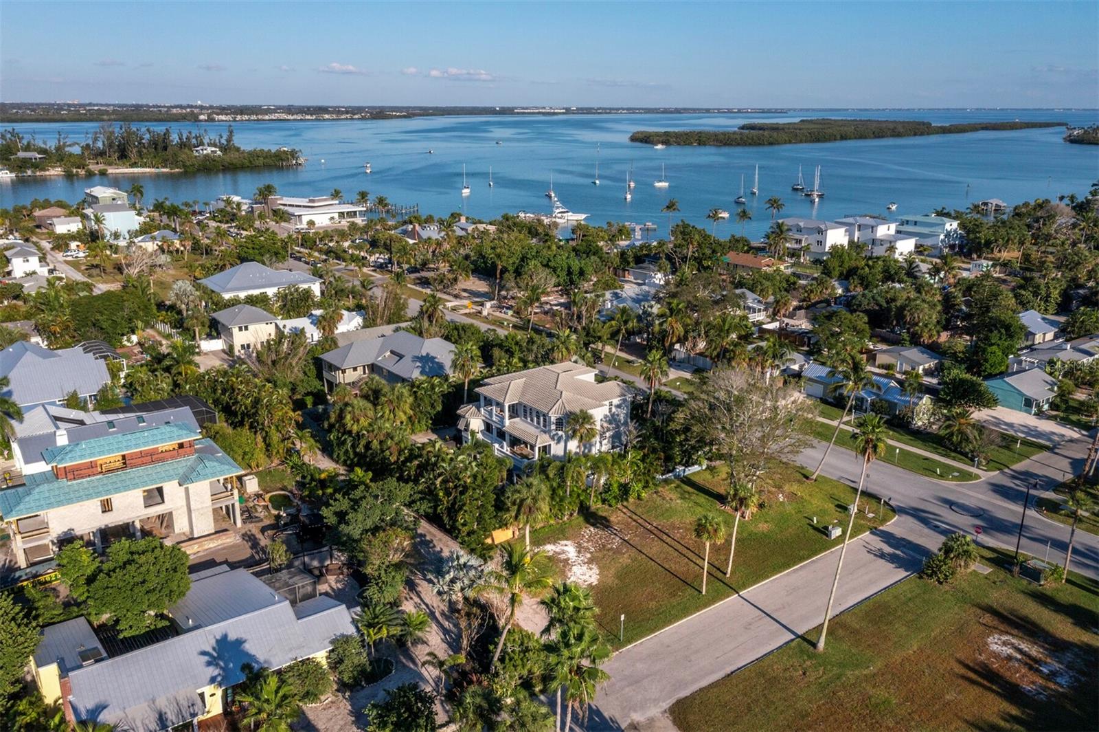 Discover the irresistible charm of historic Longbeach Village and seize a rare opportunity to build your dream island home on Longboat Key. Welcome to the lowest priced vacant single-family parcel available in the Village, an exceptional chance to design a custom residence just off the coast of Sarasota. This desired corner lot in the heart of the village offers flexible design possibilities, including optional rear alley access in addition to two street frontages, giving you potential entry on up to three sides of the property. Positioned within this golf-cart-friendly community, the homesite provides effortless access to everything that makes Longbeach Village so beloved. Enjoy the dazzling white sands and shimmering turquoise waters of the Gulf of Mexico just moments from your door, along with the serene beauty of Sarasota Bay at opposite end of Broadway, both only about a block away. Here, sunrise and sunset become part of your daily routine. Residents of the village enjoy numerous waterfront conveniences, including multiple neighborhood kayak launch points, two fishing piers, a community boat ramp and a variety of dining, shopping and fitness options within minutes of home. With no mandatory HOA, you can store your boat, golf cart, or other island toys beneath a beautiful new elevated home and fully embrace the relaxed coastal lifestyle. This exceptional piece of island real estate invites you to bring your vision to life. Start planning your dream home or private vacation retreat today and experience the unmatched charm of Longbeach Village for yourself.