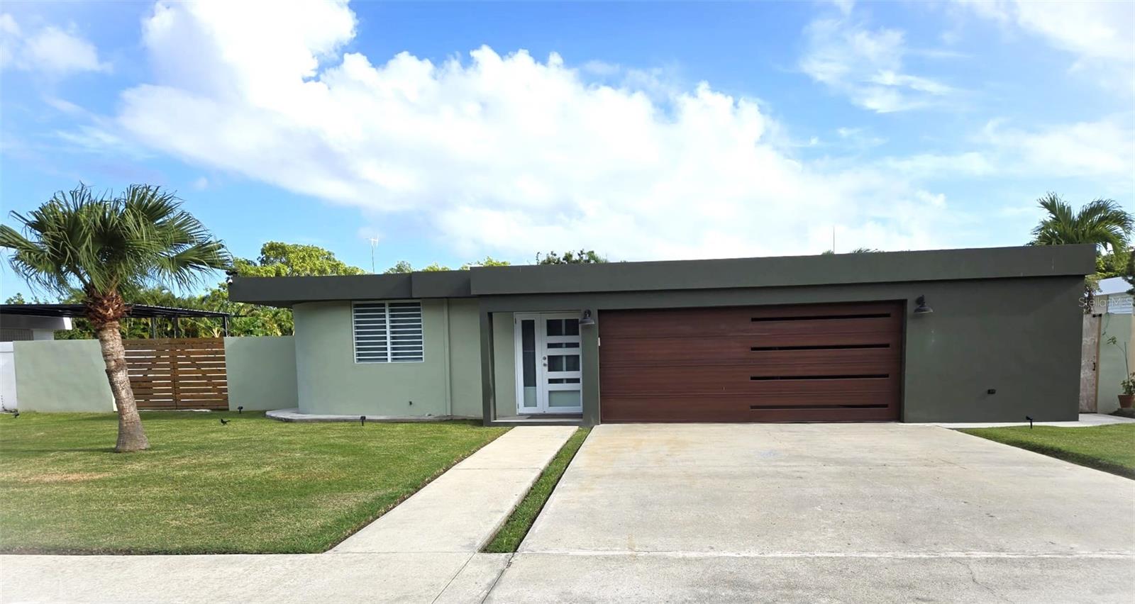 Impressive and beautifully upgraded single story residence in the exclusive gated community of Roosevelt Garden in Naguabo. This move in ready home showcases exceptional style and comfort, featuring 3 spacious bedrooms, 2 tastefully remodeled bathrooms, a bright and inviting living dining area, and a fully renovated kitchen with modern finishes that elevate the entire space. The property includes a two car garage with electric door, dedicated storage, and an expansive ~1,000 m² lot offering endless outdoor enjoyment and future potential. Delivered fully equipped with appliances, four inverter A/C units, washer and dryer, on demand water heater, security door, and a powerful 10 KW generator, solar water heater, security camaras, and cement fence that need skim coat. Recently painted inside and outside and with roof treatment completed. This residence stands out for its pristine condition and prime location just minutes from Highway 53, between Humacao and Fajardo. A rare opportunity to own a meticulously maintained home in a peaceful, highly desirable close community with tele-entry.