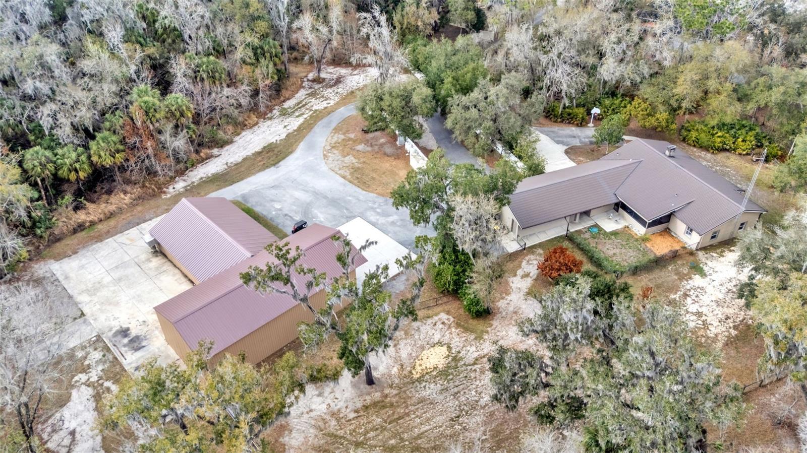 Experience space, strength, and self-sufficiency on 9+ private acres in this energy-efficient 3-bedroom, 2-bath home tucked away at the end of a cul-de-sac with two conjoined expansive shops. The workshops are 30x60 and 51x32 providing 3,500 square feet with multiple points of entrance including a 14ft high roll up door perfect for you RV or Boat storage. Designed for durability and performance, this well-built residence features R-40 insulated walls and an R-70 insulated metal roof, delivering exceptional year-round efficiency and comfort. The polystyrene concrete post-and-beam construction ensures long-term structural integrity and low maintenance.

A whole-property backup power system provides peace of mind with an Onan generator (45 kW three-phase / 30 kW single-phase) and 200-amp automatic transfer switch. The generator powers both the home and shops and includes a dedicated propane tank—ideal for uninterrupted living.

Interior and system upgrades include a new AC and heat pump, recently cleaned HVAC ducts with new registers and vents, and a gable attic fan to enhance ventilation and efficiency.

Water, Power & Utilities:
 • Connected to both city water and a private well (new well pump installed)
 • City and well water lines extended to the rear shop
 • Irrigation system supplied by well water
 • Gas line connected to tankless water heater and porch BBQ grill. 

With extensive workshop space, resilient construction, and premium utility infrastructure, this property offers a rare opportunity for those seeking privacy, functionality, and energy independence in Lakeland.

The expansive acreage creates endless opportunities for outdoor adventures. With room to roam and the tranquility of nature right outside your door, this property delivers the rare combination of seclusion and community. It’s more than just a home, it’s a private family haven designed for comfort, security, and lasting memories.