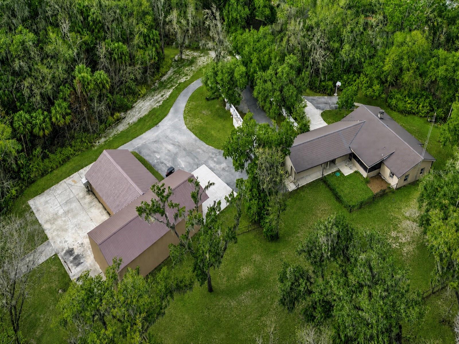Experience space, strength, and self-sufficiency on 9+ private acres in this energy-efficient 3-bedroom, 2-bath home tucked away at the end of a cul-de-sac with two conjoined expansive shops. The workshops are 30x60 and 51x32 providing 3,500 square feet with multiple points of entrance including a 14ft high roll up door perfect for you RV or Boat storage. Designed for durability and performance, this well-built residence features R-40 insulated walls and an R-70 insulated metal roof, delivering exceptional year-round efficiency and comfort. The polystyrene concrete post-and-beam construction ensures long-term structural integrity and low maintenance.

A whole-property backup power system provides peace of mind with an Onan generator (45 kW three-phase / 30 kW single-phase) and 200-amp automatic transfer switch. The generator powers both the home and shops and includes a dedicated propane tank—ideal for uninterrupted living.

Interior and system upgrades include a new AC and heat pump, recently cleaned HVAC ducts with new registers and vents, and a gable attic fan to enhance ventilation and efficiency.

Water, Power & Utilities:
 • Connected to both city water and a private well (new well pump installed)
 • City and well water lines extended to the rear shop
 • Irrigation system supplied by well water
 • Gas line connected to tankless water heater and porch BBQ grill. 

With extensive workshop space, resilient construction, and premium utility infrastructure, this property offers a rare opportunity for those seeking privacy, functionality, and energy independence in Lakeland.

The expansive acreage creates endless opportunities for outdoor adventures. With room to roam and the tranquility of nature right outside your door, this property delivers the rare combination of seclusion and community. It’s more than just a home, it’s a private family haven designed for comfort, security, and lasting memories.