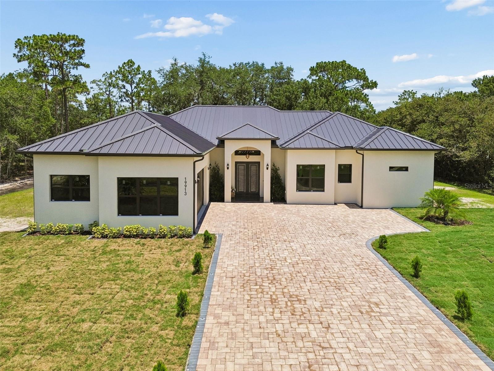 BRAND NEW  LUXURY CONSTRUCTION ON 1.24 ACRES WITH SOARING CEILINGS! Welcome to this spectacular, newly built 4-bedroom, 4-bathroom masterpiece in the highly desirable community of Wedgefield. This custom-built residence greets you with dramatic high ceilings that amplify the natural light and create an immediate sense of grand scale. The open-concept layout features high-end modern finishes, a gourmet kitchen engineered for entertaining, and a sprawling primary suite with a spa-inspired bath. Please note: Most areas of the home are beautifully staged to showcase the ultimate layout potential. Outside, your massive 1.24-acre lot offers a completely private canvas for a custom pool, detached workshop, or private oasis. Conveniently positioned with seamless access to the Beachline (SR 528) and Lake Nona Medical City. Never lived in, meticulously designed, and ready for you. 
Here are some important fixtures about this property.
ROOF & EXTERIOR
- SnapLock Standing Seam 24-gauge metal roof with PVDF paint finish (premium over standard 26-gauge nail strip with SMP)
- All impact windows and doors throughout, including garage
- Insulated garage door with smart opener (app-controlled)

STRUCTURE & SITE
- Lot is entirely upland — no wetland designation
- CBS construction
- Plate height 12', tray ceilings add 1' for a finished height of 13' in tray rooms; front and rear covered porches are 14'
- Total conditioned area: 2,499 SF | Total under roof: 3,643 SF

INSULATION
- Continuous R-6 rigid foam on interior face of CMU walls
- R-38 ceiling insulation
- R-13 in all interior partition walls for thermal comfort and sound attenuation

HVAC & MECHANICAL
- Trane 5-ton heat pump, AHRI certified, manufactured November 2025, assembled in USA — 10-year parts and compressor warranty (registered)
- Hybrid heat pump water heater, 65-gallon, 4.05 UEF (vs. ~0.90–0.95 for a standard tank)
- Dual-stage water filtration system (salt and chlorine)

FLOORING
- 24x48 porcelain tile throughout

INTERIOR FINISHES
- Solid wood cabinets, soft-close hinges and drawer slides, glass-front upper doors with integrated LED lighting
- ½" shower glass (vs. standard ¼")
- Delta fixtures throughout all showers
- Delta comfort-height toilets with soft-close seats throughout

APPLIANCES
- 48" dual-fuel range
- 60" built-in-style refrigerator
- 48" range hood
- Built-in microwave/wall oven
- Full stainless steel suite throughout

Don't miss this opportunity , make your appointment today. Call or text for more information.