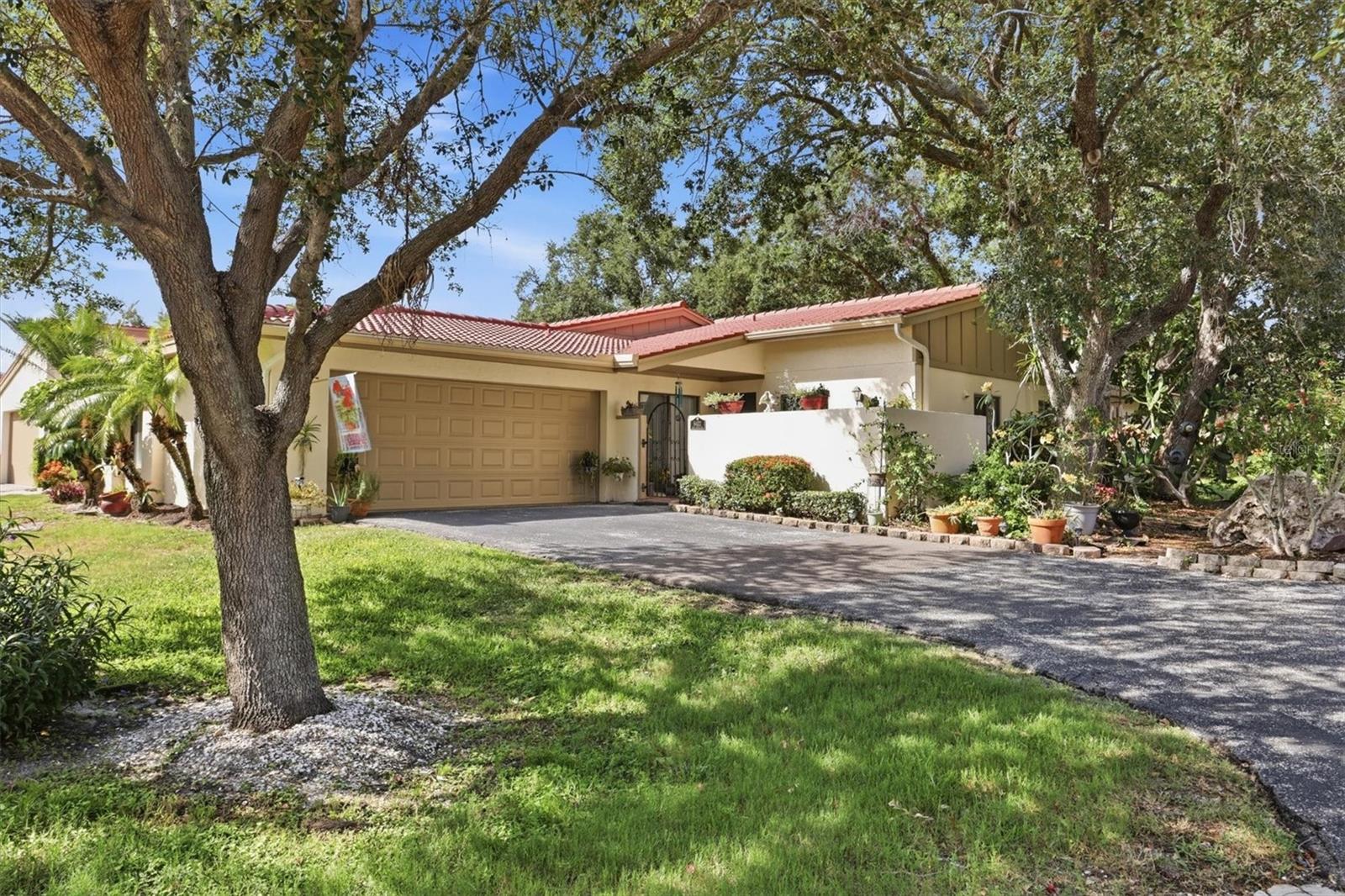 Tucked beneath a canopy of oaks in the bayfront community of Wild Oak Bay, this maintenance-free villa offers a peaceful retreat surrounded by natural beauty. Relish tranquil pond views from the Florida room and spacious paver patio, where a sparkling fountain and abundant wildlife create a serene backdrop. Savor a cup of coffee watching the sunrise filter through the trees as birds greet the day, then unwind in the evening to the soothing sounds of the fountain. A charming, gated courtyard with a paver patio welcomes you while providing an added sense of privacy. Inside, vaulted ceilings and wood-look plank flooring enhance the open, inviting living spaces. The updated kitchen features shaker cabinetry, quartz countertops, and newer stainless-steel appliances, while the living room fireplace adds warmth and character. The primary bedroom has an en-suite bath, walk-in closet and sliders that open to the Florida room. The guest bedroom has sliders opening to the courtyard. A flexible den provides the perfect space for a home office, media room, or guest bedroom for visiting family and friends. Multiple sliding glass doors and windows bring the outdoors in and provide plentiful natural light. The oversized two-car garage features a new impact-rated garage door, while a new water heater (2026) and new roof (2026) add peace of mind. Ideally located just steps from the community pool and close enough to enjoy glimpses of Sarasota Bay, this villa offers the perfect balance of privacy and convenience. The tranquil pond, fountain, mature oak canopy, and frequent visits from native birds create a setting that feels worlds away yet remains close to everything the Sarasota-Bradenton area offers. Gulf beaches, shopping, dining, SCF, IMG Academy, and SRQ Airport are all just minutes away. Golf enthusiasts will appreciate the opportunity to join nearby IMG Country Club and enjoy year-round golf, dining, and social activities. Whether you're seeking a full-time residence, seasonal retreat, this villa offers the perfect combination of natural beauty, comfort, and convenience.