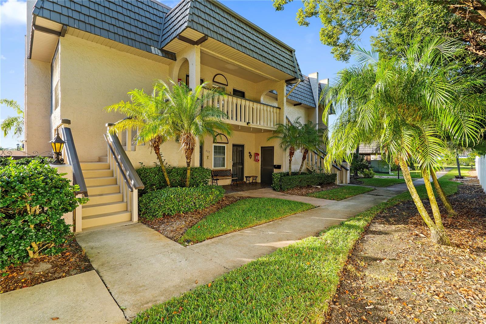 Welcome to Cordova Greens I, located on the east side of the community. This second-floor walk-up condo is surrounded by mature landscaping and lush greenery. Tucked along the east side of Building 5, the front porch balcony provides a peaceful setting with no direct view of neighboring condos. Upon entry, rich-toned vinyl flooring flows throughout the main living areas, while vaulted ceilings and curved archways add character and create a bright, open feel. Designed for functional everyday living, the U-shaped kitchen provides generous counter space, abundant cabinetry, stainless steel appliances, and a convenient pass-through to the dining area. In the foyer that is attached to the kitchen and unique to this unit is a deep pantry and wide coat closet. Exceptional storage throughout the unit sets this floor plan apart from similar models. Beyond the kitchen, the dining area and living room combine to create an expansive great room for gathering with family and friends. Adjacent to the living room, the cooled Florida room is separated by sliding glass doors and offers flexible space for a home office, reading room, or sitting area. The two sets of sliding doors allow the space to be opened for fresh air or closed for privacy. The hallway leading to the two bedrooms encompasses a linen closet, laundry closet with side-by-side washer and dryer, and a utility closet for the water heater and extra storage. The oversized primary bedroom is a suite, complete with a walk-in cedar closet, vanity with room for a makeup chair, dual sinks that are separated by a pocket door, and an elevated garden bathtub. The second bedroom comfortably accommodates two twin beds or a queen-sized bed, while the guest bathroom has an extended vanity and a walk-in shower. Included with the condo is a private storage area beneath the south-side stairs and a personal mailbox located on the first floor (no walking to a community mailbox station). Carport parking space #4 is right in front of Building 5. Guests may use any spaces marked Visitor Parking, including the covered visitor parking space. The heated community pool and hot tub area shared by Cordova Greens I, II, and III is the focal point of neighborhood activity. Maintained at approximately eighty-seven degrees year-round, the pool is designed for comfortable use throughout the seasons rather than only during the summer months. Situated within the Bardmoor neighborhood, the location is close to shopping, restaurants, gyms, banks, and medical offices. Homeowners have the option to join two nearby country clubs that offer golf, dining, and social activities. Nature lovers will appreciate being near Lake Seminole Park, while the Gulf beaches are less than fifteen minutes away. Cordova Greens I is a smaller association comprising thirty-eight condominiums, is not land-leased property, and is located outside the flood zones. The monthly condo fee covers all utilities except electric, including Spectrum high-speed internet and cable, water, sewer, trash collection, landscaping, pool maintenance, and exterior building maintenance, including the roof. Residents of all ages are welcome, and the community permits one dog up to twenty pounds. Cats, birds, and fish are also allowed inside the condo. With over 1500 square feet, this uniquely positioned property is an ideal winter retreat or a full-time residence. Additional info in the Property Feature Sheet. Contact your Realtor to obtain a copy and to schedule a showing.