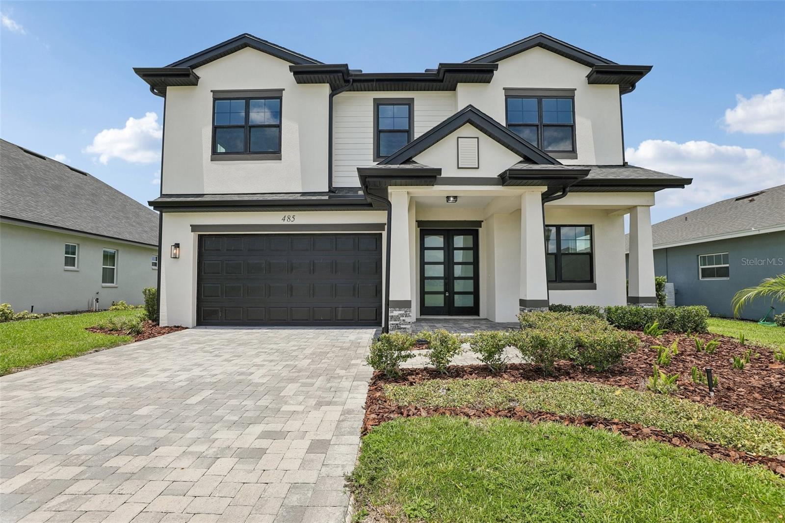 Completed in 2024 and never lived in, this impeccably finished new construction home in the gated, amenity-rich Water Ridge community offers the kind of elevated design and thoughtful detail that is genuinely hard to find at any price point. From the moment you pull up to the striking white and black exterior — with its clean architectural lines, manicured landscaping, and paver driveway — it is clear this home was built with intention.
Step inside and the kitchen immediately commands attention. Floor-to-ceiling white shaker cabinetry, a dramatic waterfall quartz island with a contrasting dark base, a built-in double oven, cooktop with a stainless steel range hood, and a dedicated wine refrigerator come together to create a space that is as functional as it is stunning. Generous bonus storage room just off the kitchen — an unexpected and highly functional space, complete with wood-look flooring, built-in shelving, and vaulted ceiling, perfect for a pantry, hobby room, or organized storage. Pendant lighting, recessed cans, and warm wood-look flooring carry the eye through the open-concept living and dining areas, where natural light pours in and the space flows effortlessly — perfect for everyday living and entertaining alike.
Both bathrooms are finished to a spa-like standard. The primary bath features a double vanity with quartz countertops, custom cabinetry with matte black hardware, designer globe lighting, and a floor-to-ceiling marble-look tile walk-in shower with a glass enclosure and mosaic tile flooring. The secondary bath mirrors the same elevated finishes with its own walk-in shower, quartz vanity, and natural light from a bright window. The primary bedroom is conveniently located on the main floor and includes a generous walk-in closet, tray ceiling, and smart home integration throughout.
Life in Water Ridge is a community experience unlike most. As a gated lakefront community, residents enjoy access to a community boat ramp, lake and water access, a clubhouse, fitness center, resort-style pool, tennis courts, park, and golf cart-friendly streets — all set within a beautifully maintained, deed-restricted neighborhood with reclaimed water irrigation.
This is new construction quality with immediate availability — no wait lists, no builder timelines, just a move-in ready home that feels brand new because it is.