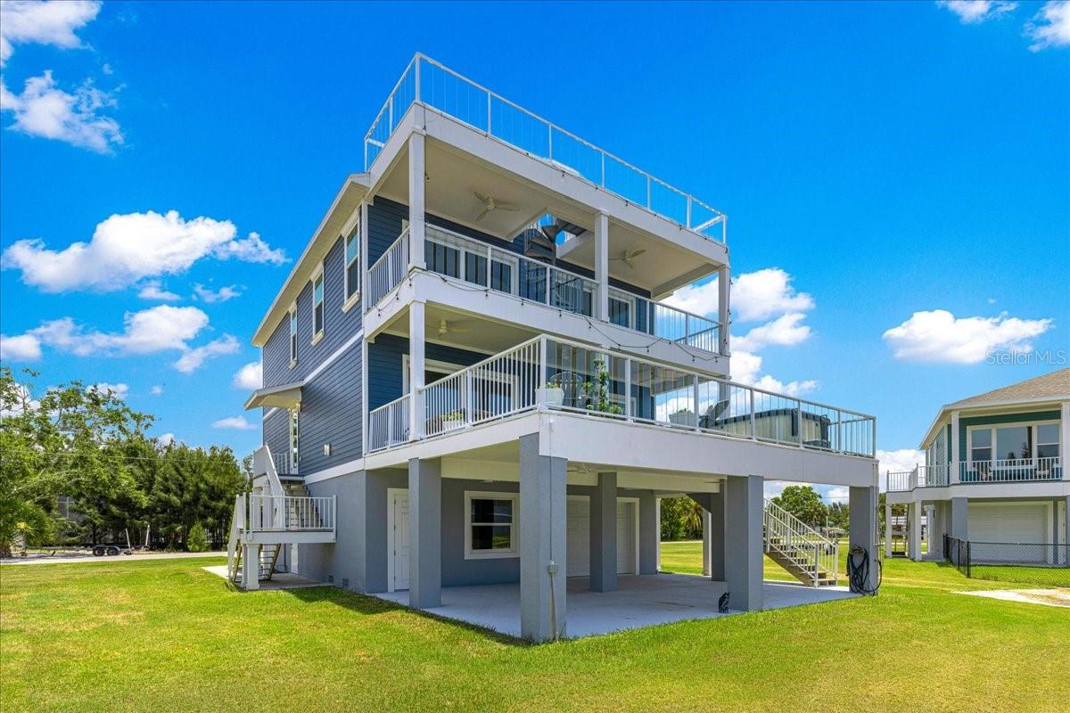 Experience luxury waterfront living in this exceptional custom-built coastal residence located in the desirable Driftwood Isles community of Hudson. Built in 2022 and thoughtfully designed for both everyday living and entertaining, this stunning 4-bedroom, 3-bath home offers approximately 2,400 square feet of beautifully appointed living space, a private elevator servicing every level, expansive outdoor living areas, and direct Gulf access from your own backyard.

Step inside to discover an open-concept floor plan highlighted by soaring ceilings, luxury finishes, abundant natural light, and a spectacular chef's kitchen featuring an oversized quartz island, custom cabinetry extending to the ceiling, stainless steel appliances, designer lighting, abundant storage, and a spacious walk-in pantry. The kitchen flows effortlessly into the living and dining areas, creating the perfect space for hosting family and friends while enjoying beautiful water views.

The spacious primary suite offers a peaceful retreat complete with a private waterfront balcony, generous walk-in closet, and an elegant spa-inspired ensuite bath featuring dual vanities and a large walk-in shower. Three additional bedrooms provide ample space for family, guests, or a home office.

Designed to embrace the Florida lifestyle, this home offers multiple outdoor living spaces including a large, covered balcony overlooking the canal, an expansive rooftop deck with panoramic views, and a spacious covered ground-level patio perfect for entertaining after a day on the water.

Boaters will appreciate the direct canal frontage with quick access to the Gulf of America, making it easy to enjoy fishing, island hopping, sunset cruises, and endless waterfront adventures. The oversized garage provides exceptional space for multiple vehicles, golf carts, kayaks, fishing gear, and all your waterfront toys, while the elevator offers convenient access from the garage to every floor.

Ideally located just minutes from waterfront restaurants, marinas, shopping, medical facilities, beaches, and the Suncoast Parkway, this home provides an easy commute to Tampa International Airport and downtown Tampa while allowing you to enjoy the relaxed lifestyle of Florida's Nature Coast.

Whether you're searching for a full-time residence, luxury vacation home, or waterfront retreat, this exceptional Driftwood Isles property delivers modern construction, quality craftsmanship, and the ultimate coastal lifestyle.

This is Florida waterfront living at its finest—where every day feels like a vacation.