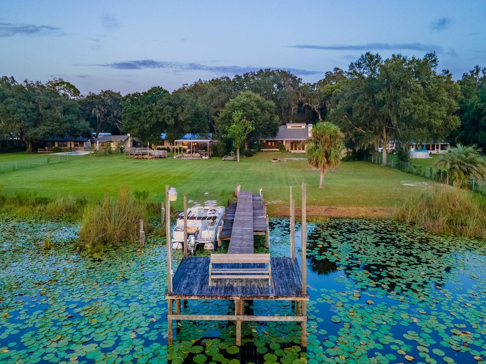 Situated on 2.19 acres with 200 feet of waterfront on Little Lake Kerr, this unique property offers spectacular sunsets, privacy, and room to entertain. The estate features both a custom-built main home (2005) and a guest home, perfect for multi-generational living or hosting extended family and friends.

The main home includes 3 bedrooms, 2 bathrooms, plus a half bath outside for lake and work days. With 1,761 sq ft under heat and air, the home features vaulted ceilings, abundant natural light, and an open floor plan. The custom kitchen includes cherry cabinets, granite countertops, double ovens, glass cooktop, double-drawer dishwasher, and large sink with bar area. The spacious primary suite (15’x19’) includes a walk-in closet and en suite with tiled walk-in shower, vanity, and private toilet area. Guest bedrooms share a Jack & Jill bath with tiled tub/shower combo. A wood-burning fireplace anchors the living room with lake views, while French doors open to a rear covered porch, fire pit, and landscaped backyard. Additional features include a 24’x12’ carport, laundry/utility room, and screened area off the living room.

Outdoor living shines with a 24’x24’ covered gazebo (power, lights, ceiling fans, and hot tub), above-ground pool with sun deck, large multi level dock for the boat and a concrete boat ramp.

The guest home (1974 mobile home with full-length addition) offers 1,344 sq ft, 2 bedrooms, 2 bathrooms, dining area, updated kitchen with range, refrigerator, island, custom cabinets with wood countertops, and a 46’x12’ living room with three large picture windows overlooking the lake. Several storage buildings are located between the two homes.

Surrounded by the Ocala National Forest, this property is minutes from the Salt Springs Recreation Area, Lake George, and the St. Johns River. The area offers endless opportunities for boating, fishing, hunting, hiking, and trail riding, with everyday conveniences just minutes away. Only 30 minutes to Ocala or Palatka.

This is a one-of-a-kind lakefront retreat combining privacy, modern updates, and multiple residences—perfect for year-round living or as a family getaway.