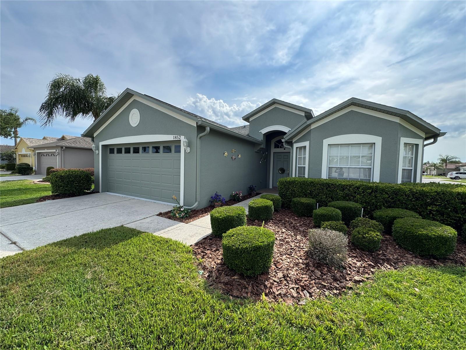 One or more photo(s) has been virtually staged. Beautiful Corner Lot Waterfront Home in Heritage Springs Golf & Country Club – 55+ Gated Community. This rare opportunity features a well-maintained corner lot home with serene waterfront views and lush landscaping in the desirable 24/7 guard-gated Heritage Springs community. Inside, you’ll find a grand tiled foyer with cathedral ceilings, a massive kitchen with ample cabinetry, oversized pantry, breakfast area, and all appliances. The open-concept living and dining areas are perfect for entertaining, highlighted by a striking green chandelier and soaring cathedral ceilings.The spacious floor plan includes a large master suite with walk-in closet and luxurious en-suite bath (dual sinks, private toilet, walk-in shower), a guest bedroom with walk-in closet, a flexible office/den (potential 3rd bedroom), plus generous storage, a tiled laundry room, and a double car garage. Relax on the screened patio while enjoying breathtaking sunsets.Community Highlights: Newly renovated pool & clubhouse, golf course, daily social events, dancing, and maintenance-free lawn care.Perfect low-maintenance retirement living in Trinity, FL. OWNER IS A REALTOR®