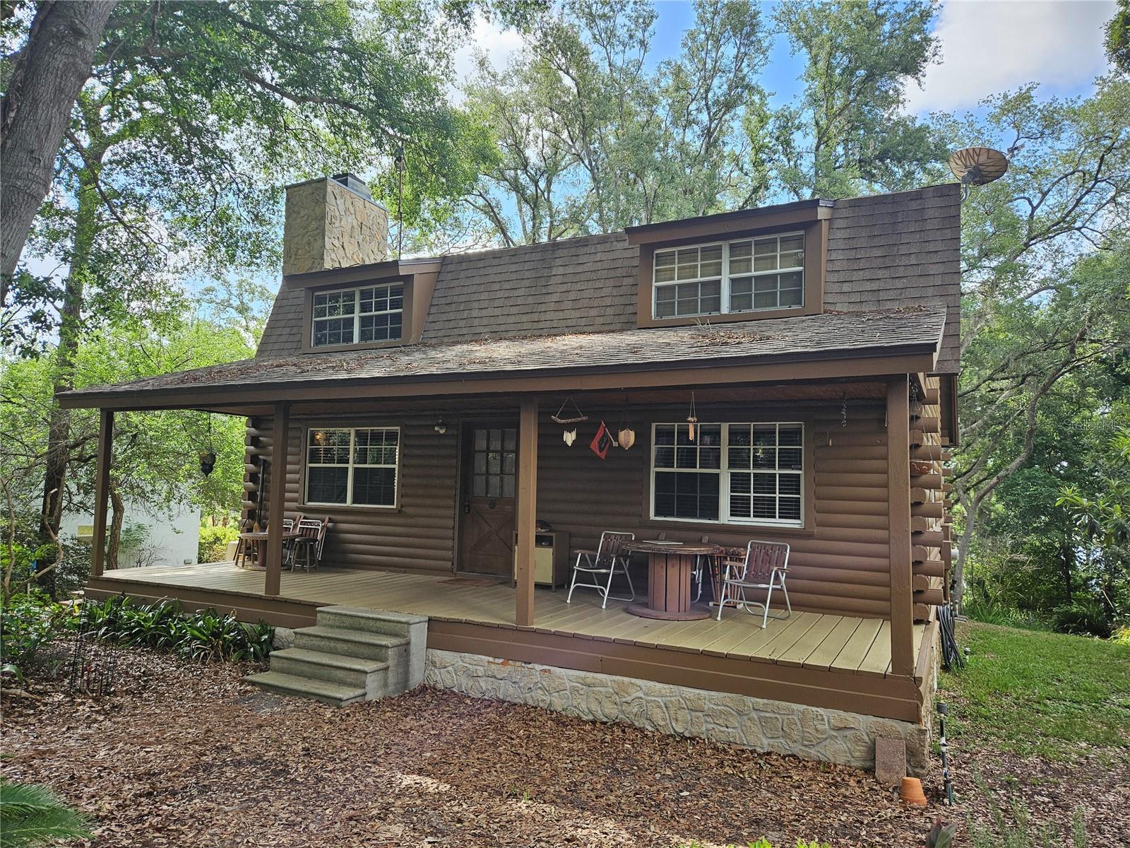 This can be your quiet, private Log Cabin on 1.3 acres with Lake Avalon frontage, wooded lot with Large Oaks and Azaleas.
This enchanting home is 3 bedrooms, 2.5 baths, with large great room and kitchen/dining room combo.  All bedrooms are upstairs.
Enjoy your evenings on 1 of 2 porches that run the length of the home on both the front and the back of the home. The wooded lot has beautiful Oaks, and is a slice of old Florida where you can enjoy birding, and gardening. This home has a separate oversized garage, and a storage shed for your toys. Enjoy the private lakefront, (residents only) access to Lake Avalon, a fisherman's paradise! Situated in the rural community of Lake Avalon Heights with a low HOA, it is located close to shopping, Attractions, and highway access. This home has been meticulously maintained, and you can make it yours and move in with no worries!