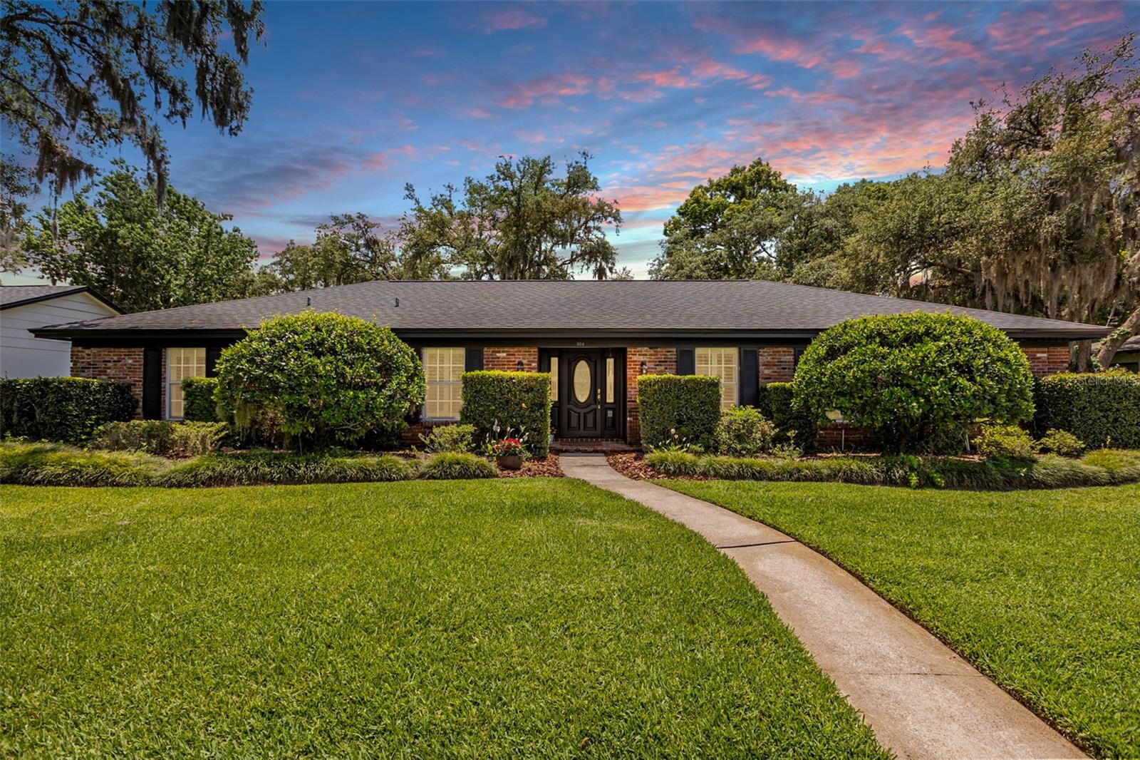 Welcome to La Floresta — one of Altamonte Springs' most exclusive and ESTABLISHED NEIGHBORHOODS (with NO HOA) where homes rarely come available. If you've been waiting for the right one, this is it. Offered by the ORIGINAL OWNER, this stately 4 bedroom, 2.5 bath SINGLE-STORY HOME makes an immediate impression with its CLASSIC BRICK FACADE and impeccably MANICURED LANDSCAPING. From the moment you step into the DEDICATED FOYER, the craftsmanship and attention to detail are evident — CROWN MOLDING, PLANTATION SHUTTERS, BUILT-INS, and ELEGANT TRIM WORK flow throughout, giving this home a level of character and refinement that is hard to find. FORMAL LIVING AND DINING ROOMS sit just off the foyer to the right, creating a gracious and dedicated space perfect for hosting holidays, dinner parties, or simply enjoying a slower Sunday morning with family. The EAT-IN KITCHEN features UPDATED CABINETRY, a top-of-the-line Bosch stainless steel refrigerator, WALK-IN PANTRY, and a charming WINDOW OVER THE SINK that fills the space with NATURAL LIGHT. The kitchen flows effortlessly into the family room and with its layout, could easily be opened up for a more MODERN OPEN CONCEPT FEEL. A dedicated INDOOR LAUNDRY ROOM and GUEST HALF BATH round out the main living areas. Every bedroom is generously sized with an ABUDANCE OF CLOSET AND STORAGE SPACE — a rare find. The private primary suite is your own personal retreat, featuring an en suite bathroom with a beautifully REMODLED WALK-IN SHOWER AND GRANITE VANITY. The second full bathroom offers a LARGE DUAL SINK VANITY and tub/shower combo. Out back, an ENCLOSED GLASS PATIO extends your living space year-round — imagine morning coffee, evening cocktails, or weekend gatherings — all opening to a LARGE FULLY FENCED BACKYARD with plenty of room to roam. An OVERSIZED 2-CAR GARAGE completes the package. This home was lovingly cared for and is ready to welcome its new owners. Location could not be more convenient — situated in Altamonte Springs bordering Maitland, you are just minutes from the Altamonte Mall, Cranes Roost Park, AdventHealth, SunRail, and an abundance of dining, shopping, and entertainment. Winter Park and Maitland amenities are equally close, and I-4 ACCESS IS QUICK AND PAINLESS. Plus, close to Lake Orienta Elementary school, JCC and private schools ST MARY MAGDALEN CATHOLIC SCHOOL and ORANGEWOOD CHRISTIAN SCHOOL. Everything you need is right at your doorstep. Additional peace of mind comes with a NEW ROOF (2022), REPLUMBED (2022), NEW WATER HEATER (2021), HVAC (2019) in great shape & recently serviced— big ticket items already done for you. Homes in La Floresta don't last — don't miss your opportunity!