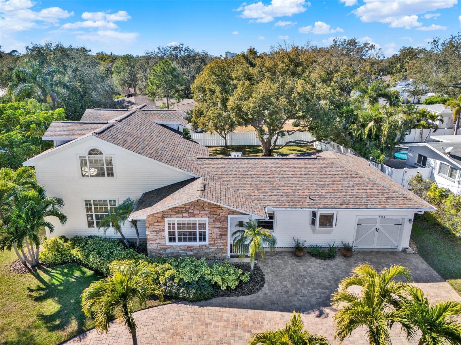 BEAUTIFULLY MAINTAINED BELLEAIR HOME SITUATED ON OVER 1/4 ACRE ON A LOW-TRAFFIC DEAD-END STREET! Exceptional curb appeal welcomes you with mature landscaping and a circular paver driveway. Offering 3,008 sq ft of living space, this 3BR/3BA residence with a dedicated office, bonus room, and interior laundry room blends timeless charm with thoughtful modern updates. The spacious living room, family room, and dining room provide ample space for both everyday living and entertaining. Gorgeous hardwood floors and abundant natural light enhance the warm and inviting atmosphere throughout. The gourmet kitchen is a chef’s dream, featuring granite countertops, stainless steel appliances, an attractive backsplash, and a convenient breakfast bar. The expansive primary suite includes a WALK-IN CLOSET with custom built fixtures, private access to the back deck, and a well-appointed bath with double-sink vanity, jetted tub, and walk-in shower. THE 1ST FLOOR ALSO OFFERS A SPACIOUS 2ND BEDROOM AND A PRIVATE OFFICE THAT COULD EASILY BE CONVERTED INTO A FOURTH BEDROOM IF DESIRED. Upstairs, you’ll find a 3rd bedroom, full bath, and an impressive bonus room with vaulted ceilings and a wet bar—perfect for a media room, playroom, or guest retreat. Enjoy outdoor living in a beautifully landscaped backyard with mature trees, a large deck, and an expansive yard with plenty of room to add a pool. Additional highlights include well-irrigated sprinkler system, water softener, surround sound speakers, 2 NEW HVAC SYSTEMS, water heater (2020), NEW ROOF IN 2020 and a shadow box vinyl fence. Conveniently located just minutes from Belleair Country Club, pristine beaches, shopping, and dining, this move-in-ready home offers space, comfort, and an unbeatable location.  NO FLOOD INSURANCE REQUIRED. Make your appointment to see this exceptional property today!
