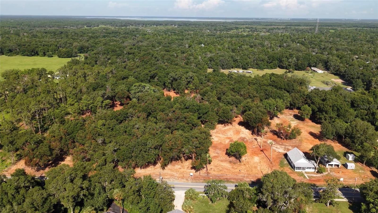 “As-is” Florida Cracker Home with detached garage on 4.58 acres of high and dry Geneva acreage with mature trees and 318’ of paved frontage, plus an adjoining parcel that is also available for purchase.  Renovate and reside, rent it out, and/or build your dream home from the ground up while leaving your income options open— this 4.58-acre Geneva property offers a rare combination of existing structures to make your own plus high, dry buildable land in one of Seminole County's rural communities. This parcel offers an existing gutted home with a screened porch, a garage, both with new roof in 2021, plus 2 storage sheds, all being offered “as is”, with potential to become guest cottage, home office, rental, or workshop spaces while offering plenty of high and dry buildable land for your new dream home!

Offering peace of mind and buildability that’s hard to find in Seminole County, this entire parcel has exceptional high elevations 70’ +/- above the water table, as for the USGS Topographic Survey Map, and is on the coveted Geneva Bubble. With approx. 318 feet of paved frontage on Old Geneva Road, the parcel offers convenient, centrally located access.

Whether you’re envisioning a private home along with guest house income potential, a  compound, or a hobby farm with room for horses and livestock plus the buildings that house them, this expansive, peaceful setting delivers room to build, expand and develop into your dream rural retreat with NO HOA.. Acreage has been thoughtfully under-brushed to showcase the beautiful mature trees while preserving the natural beauty of the land.  Bring your toys, RV’s, and boats.   12 miles to the 417, 18 miles to I-95. Convenient access to the St. Johns River, public boat ramps, the Flagler Trail and Lake Harney Wilderness Area — hike, boat, fish, and enjoy Florida wildlife. Convenient to Central Florida beaches, Space Coast, theme parks, and downtown Orlando. Property Dimensions are approximately 627’ North side, 318’ West side, 629’ South side, and 318’ East side.

Bonus Opportunity: The adjoining 9.63-acre parcel (Parcel 25) is also being offered, providing a rare chance to acquire over 14.21 combined acres in one of Geneva’s most coveted locations.