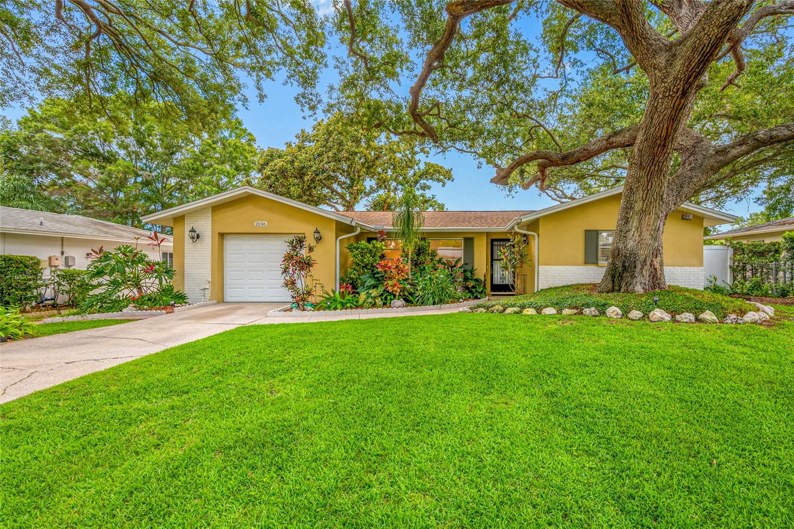 Charming Greenbriar Home Minutes from Downtown Dunedin!
Enjoy easy Florida living in the highly desirable Greenbriar neighborhood, just minutes from the heart of Downtown Dunedin. Surrounded by mature landscaping and majestic shade trees, this inviting home offers comfort, charm, and convenience in a location that’s hard to beat.
Over the past nine months, the home has received a series of thoughtful updates. The remodeled eat in kitchen features modern cabinetry, granite countertops and backsplash, newer appliances, updated fixtures, and under cabinet lighting that adds both function and ambiance. Fresh interior paint, LVP flooring, modern lighting, updated ceiling fans, new window treatments, and an indoor laundry room all contribute to a clean, contemporary feel throughout.
The dining area opens directly to the covered lanai, creating an easy indoor-outdoor flow perfect for relaxing or entertaining. Both bedrooms offer comfortable retreats, and the main bath has been refreshed with quality updates for added peace of mind.
Out back, the fenced-in yard feels like a private sanctuary—lush & tranquil. It’s an ideal spot for gatherings, gardening, or quiet evenings under the trees. Greenbriar residents also enjoy access to a community Clubhouse with Pool and Gym, offering a welcoming place for cookouts, casual get togethers, and neighborhood connection.
With close proximity to Downtown Dunedin, the Pinellas Trail, Honeymoon Island, and some of the Gulf Coast’s most beautiful beaches, this home delivers an appealing blend of lifestyle, location, and value.
Don’t miss the chance to make this beautifully updated Greenbriar home your own.