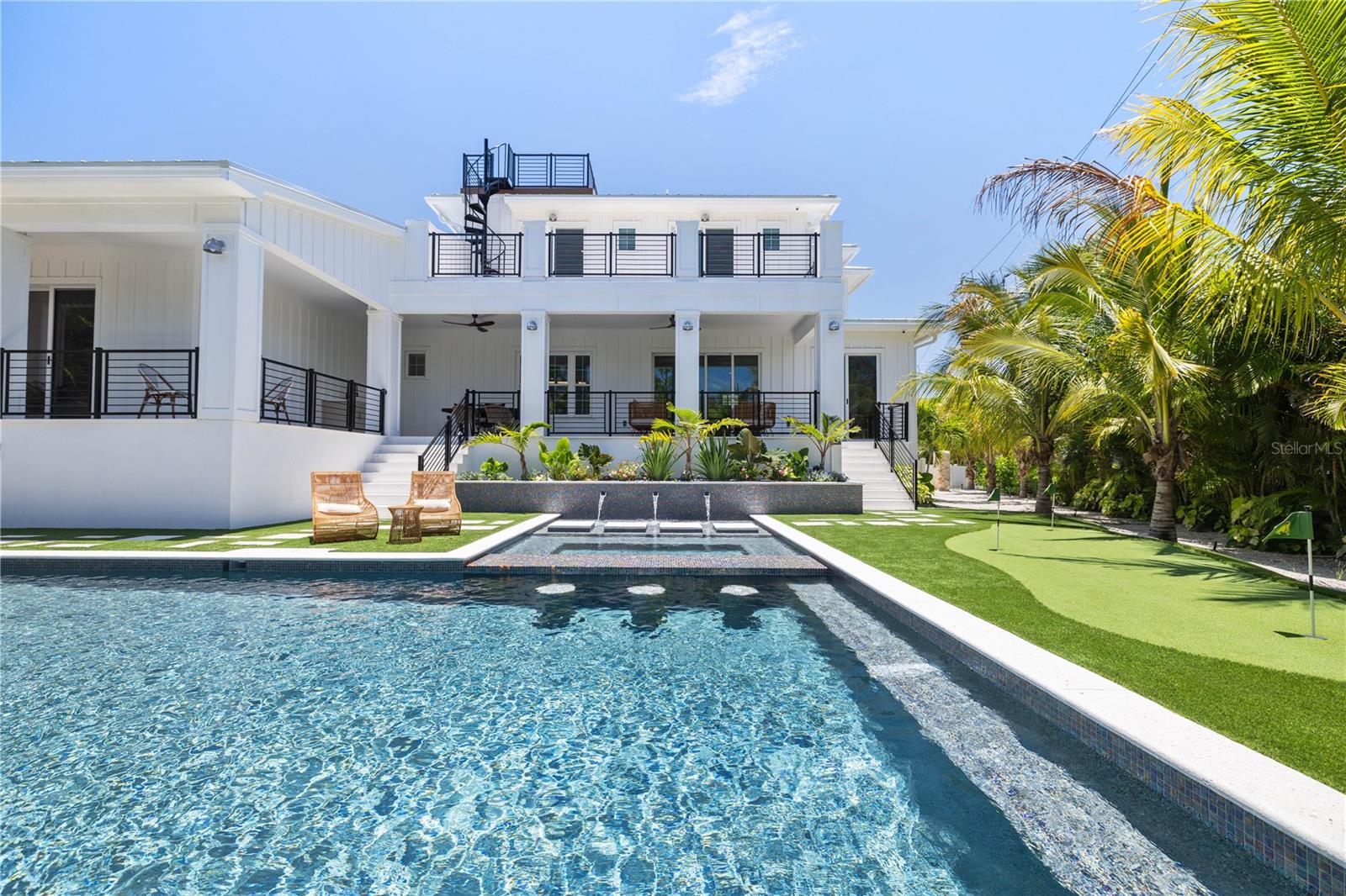 Welcome to this newly built Waterfront Home featuring a spacious 6 bedrooms, 6.5-baths with easy access to Bimini Bay and the Intracoastal Waterway from your private dock equipped with a 10,000 lb. boat lift. Positioned on a large corner lot just minutes from the beach this home is perfect for entertaining with surrounding water views from your private roof top terrace. The gourmet kitchen features a butlers pantry with wine cooler, custom cabinetry, quartz countertops, and high end appliances. The main floor master bedroom features a private patio leading to the pool plus walk-in closet. The spa-like master bathroom centers around your stand-alone tub and frameless glass shower with dual his and her vanities. All bedrooms are en suite with each bathroom having its own unique tile, countertop and vanity selection. A smart home system is included for your tv, speakers, and cameras. The private backyard features a large heated saltwater pool and spa with floating steps surrounded by lush landscaping and shell stone which also covers the lanai.  Call today for your private showing!