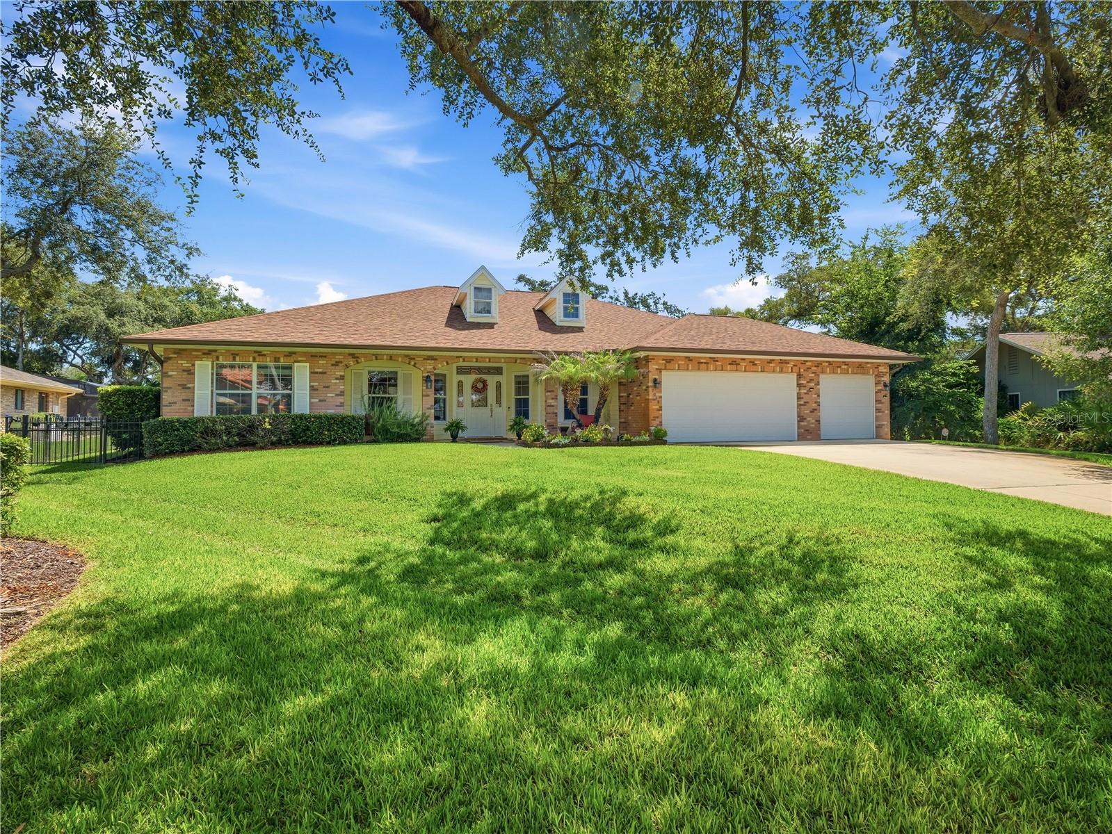 Beautifully maintained home located in the highly sought-after Sugar Mill Country Club community of New Smyrna Beach. This single-story, concrete block residence offers an open and inviting floor plan with incredible views and is designed for comfortable everyday living and easy entertaining. The home features a large office/flex space off the master suite, an oversized 3-car garage, an eat-in kitchen, a stylish dining room and an open concept living room.  Step outside to experience the fantastic backyard retreat, featuring a screened, solar-heated pool with a waterfall feature overlooking tranquil golf course views. Additional highlights include a whole-home generator, a newer roof (2023) and skylights, a fenced dog run, water filtration system and ample outdoor living space.  Quality construction, thoughtful upgrades, and an exceptional location make this home truly move-in ready.  Come take a look today and see the best Sugar Mill and New Smyrna Beach have to offer.