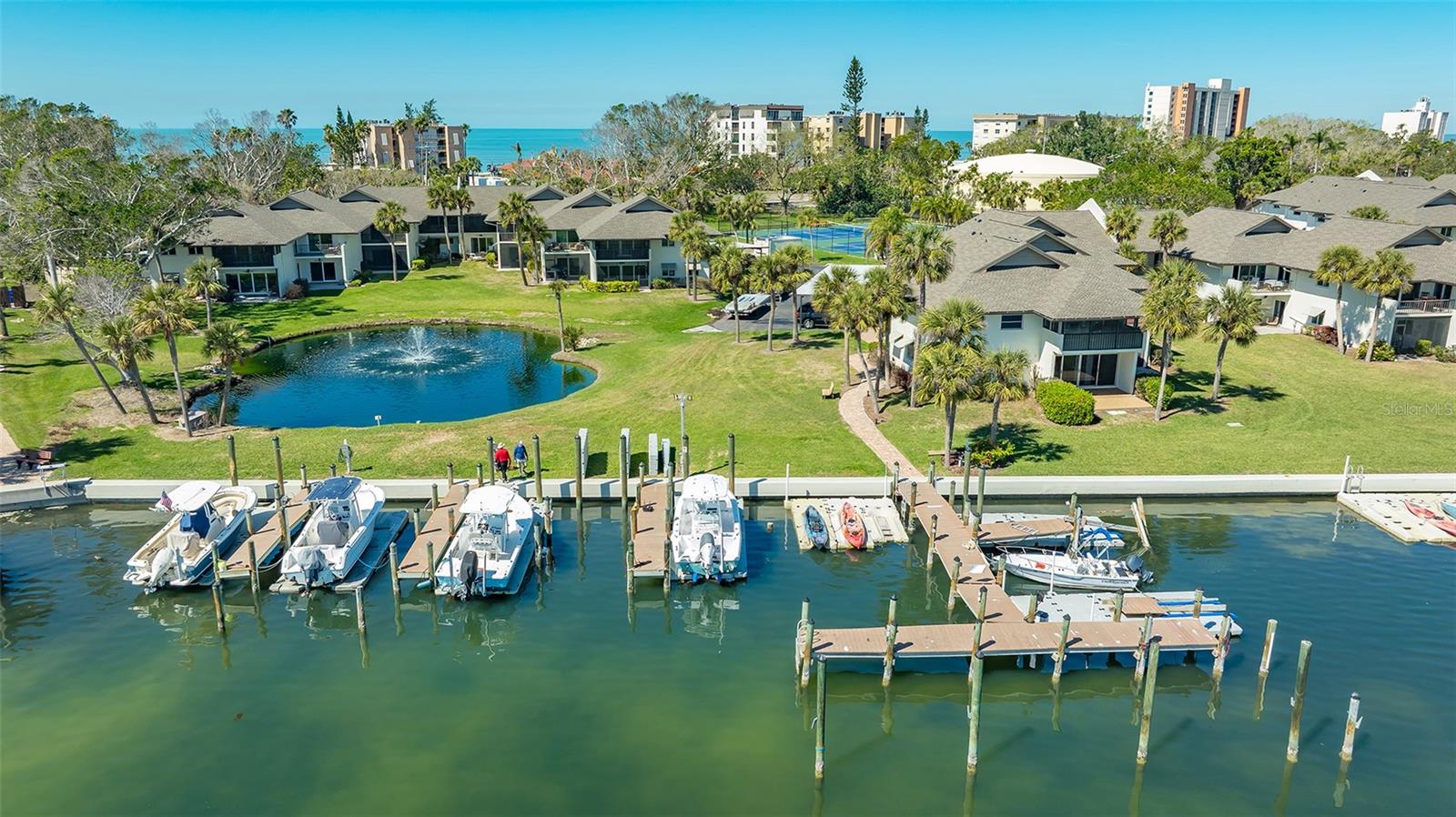 It really is all about the location- and of course the view! Situated on gorgeous Sarasota Bay, this lovely two bedroom, two bath first floor  condo offers a walk out to the sculpted grounds of Pelican Harbour and great water views of the bay from your private screened lanai. Recently professionally renovated in tasteful coastal chic, this beautifully updated condo boasts new hurricane impact windows, designer Samsung kitchen appliances, ceramic tile flooring, an island kitchen with granite countertops and white shaker wood cabinets, ceiling fans, plantation shutters, closet built-ins, washer and dryer, and new window treatments. New AC (2025). Pelican Harbour and Beach Club is a pet friendly community and offers world class amenities including private gulf beach access, a heated resort-style pool, kayak and bike storage, day dock, tennis, and pickleball. This well-maintained community has successfully completed its milestone inspection, has fully-funded reserves, and has no special assessments. Association fees include building maintenance, landscaping, building insurance, cable, water, sewer, trash, professional management, and pest control. The community has covered reserved carports, new roofs and a composite day dock that is perfect to enjoy a cup of coffee while catching those stunning Florida sunrises over water. Pelican Harbour is centrally located mid key, with convenient access to St. Armands Circle, Bayfront Park, Publix, and fine dining at a number of outstanding restaurants. Your unique opportunity to enjoy the Longboat Key lifestyle awaits!