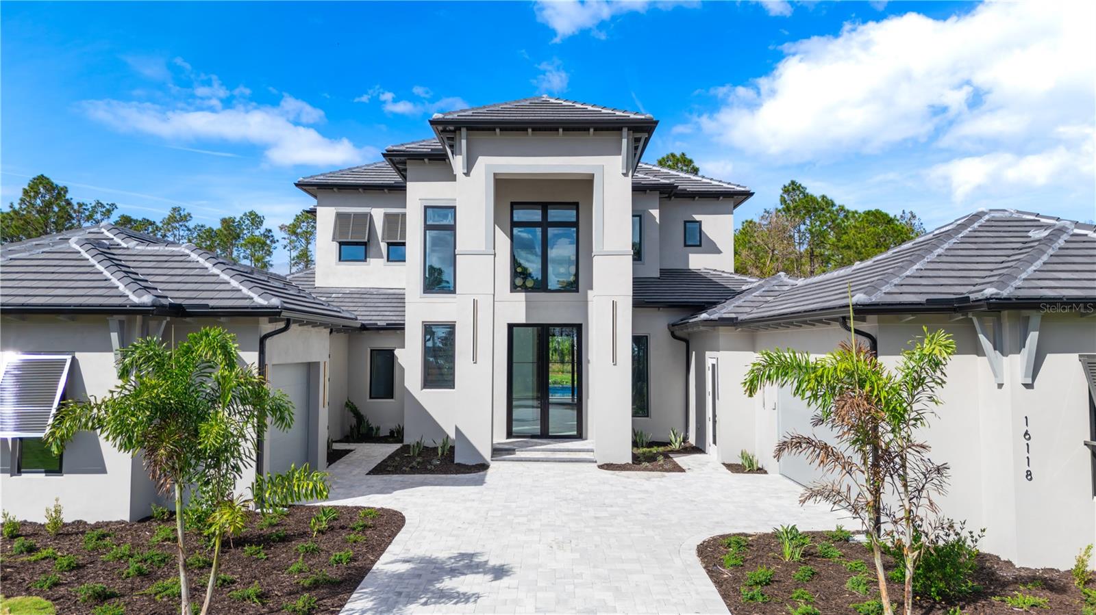 Move-In Ready * New Construction * this striking two-story custom residence on Lot 220 in Bella Collina by Delpupo Unique Homes delivers a bold architectural presence paired with thoughtful, modern livability. From the moment you enter, a dramatic two-story foyer sets the tone, anchored by a statement staircase featuring sleek glass-panel railings that draw the eye upward and flood the home with natural light.

The main living level is designed for both everyday comfort and elevated entertaining. An expansive open floor plan connects the living room, dining space, and chef’s kitchen, where a generous island, abundant cabinetry, and seamless flow create the heart of the home. Oversized 10-foot sliding glass doors - including mitered sliders in the game room - open wide to the outdoor living area, blurring the line between indoors and out.

The first-floor primary suite is a true retreat, offering privacy and flexibility with an adjoining bonus room ideal for a home gym, study, or quiet lounge. Also on the main level is a second bedroom, thoughtfully positioned with a Jack-and-Jill bath shared with a versatile third bedroom or office. A large, well-appointed laundry room adds convenience with extensive cabinetry, a utility sink, and a secondary refrigerator.

Upstairs, three additional bedroom suites each feature their own en-suite baths and walk-in closets, complemented by a spacious loft that provides the perfect setting for a media lounge or additional gathering space.

Outdoor living is nothing short of exceptional. The backyard showcases a resort-style pool and spa, a fully equipped summer kitchen, and motorized screens enclosing the entire lanai - creating a year-round extension of the home. Smart home features and multi-room audio enhance comfort and functionality throughout select living spaces.

Residents of Bella Collina enjoy a private, guard-gated lifestyle centered around a Sir Nick Faldo–designed championship golf course, a Tuscan-inspired clubhouse with fine and casual dining, a full-service spa, state-of-the-art fitness center, tennis and pickleball courts, and an active social calendar. Conveniently located just west of Orlando, Bella Collina offers the perfect balance of privacy, luxury, and accessibility.

Developer will defer the $40,000 Sports Membership deposit at closing, offering immediate value and enhanced access to the community’s premier amenities. This completed residence is ready for immediate move-in and an exceptional Bella Collina lifestyle.
