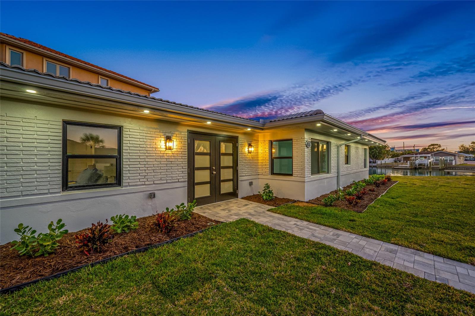 Virtually Staged. 82 ft. of WATERFRONT SAILBOAT WATER. CLOSE TO THE BEACH on a corner on a quiet Cul-de Sac. Experience luxury living and stunning water views in this completely renovated 3 bedroom, 3 bathroom waterfront oasis. Every detail has been thoughtfully designed and upgraded from top to bottom, delivering a move-in ready home that blends modern elegance with effortless coastal charm
From the moment you arrive, you’ll be drawn in by the pristine curb appeal. Step inside to an open-concept living area where sun-drenched interiors and clean lines set the tone. The living room centers around a panoramic sliding glass door wall that frames glistening water vistas.The adjacent dining space comfortably seats family and guests, with designer lighting and water-inspired accents that create a coastal-modern atmosphere.The chef’s kitchen is a masterpiece of form and function, featuring top-tier materials and stainless steel luxury appliances. Quartz countertops, a substantial 10 ft island, with seating and custom cabinetry provide ample storage and prep space. A sleek backsplash, premium faucet, and custom lighting elevate everyday cooking into an experience.Retreat to the primary suite, a serene sanctuary overlooking the water and glass sliding doors opening to the pavered deck. The spa-inspired ensuite is appointed with a glass enclosed shower, dual vanities with gorgeous lighting, and designer hardware. Two additional bedrooms each offer generous closets and easy access to full baths, one of which doubles as a stylish guest bath with premium finishes. Large walk-in closet. No detail has been overlooked in the renovation. The home features a tile roof, updated electrical and plumbing, New Hvac, New waterheater, Hurricane windows and doors, including sliding glass doors leading to the inviting pavered deck by the water.Luxury finishes include wide-plank LVP floors, LED recessed lighting.An entertainer’s dream, the backyard is a waterfront haven with direct access to the water, a stone-paved terrace, and a low-maintenance landscaped lawn. Composite dock invites boating, kayaking, paddleboarding, fishing etc, newer seawall provides peace of mind. Enjoy your morning coffee or evening cocktail watching the sun set over the Gulf. This tropical oasis enables seamless outdoor gatherings for Family and Friends.Additional features include a two-car garage and ample driveway parking. The property is ideally positioned to enjoy an easy stroll to the sugary white sands of St Pete Beach nearby dining, boutique shopping while offering quick access to major highways for an easy commutes.This completely renovated waterfront home embodies luxury, comfort, and the essence of waterfront living. It’s not just a home; it’s a lifestyle upgrade—ready for new owners to move in, unpack, and start living the dream. Schedule your private showing today to experience the refined craftsmanship and the spectacular water views that set this property apart.