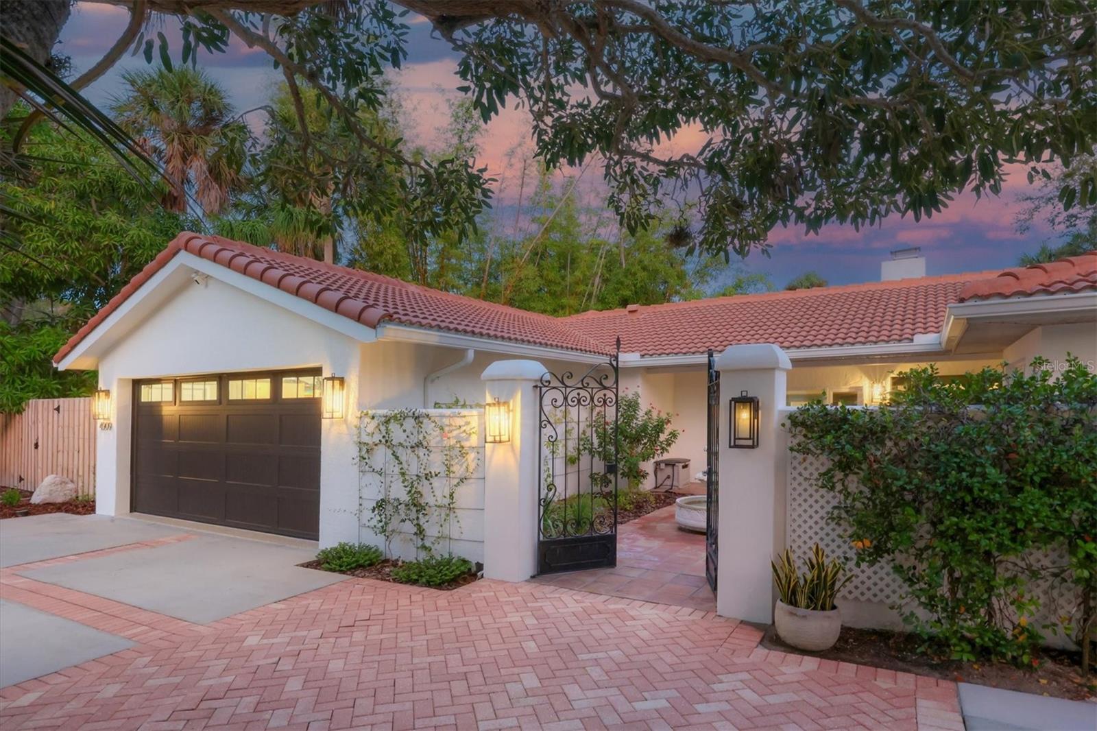 Start living the relaxed island lifestyle in this incredibly impressive Siesta Key waterfront home. This newly renovated modern, warm, move-in ready residence is perfectly positioned at the point of a basin to take advantage of its unique water front location that maximizes privacy and the tranquil water and garden views. Boat, Jet Ski, kayak, paddleboard from the dock, walk to the beach and village, or retreat to the pool and relax in this amazing indoor/outdoor living space. You will love the completely transformed open environment including entry, great room, lounge, kitchen, dining space, wine/coffee bar and laundry creating a stunning, functional, and comfortable feel throughout. The “Florida Friendly” landscaping features native plants, shrubs, and perennials that adorn the property and create a welcoming feel especially as one approaches through the private front courtyard. Once inside, the full wall of sliding doors to the pool and patio gives way to the stunning water view just beyond. Beautiful engineered hardwood floors, vaulted beamed ceilings, and a stone fireplace are just a few of the features that enhance the entryway and large great room. The heart of the home is the amazing kitchen featuring custom cabinetry with paneled appliance doors, natural stone and quartzite countertops, tile backsplash, Blanco sinks, walk-in pantry, and an extra-large rectangular island with storage and seating. High-end appliances include a Sub-Zero French Door refrigerator, GE Monogram Induction cooktop, French Door wall oven, Advantium microwave oven, Kitchen Aid dishwasher, and a Scotsman ice maker. The primary suite is a retreat and boasts Saltillo tile floors, sliding door access to the lanai, a walk-in closet, a long vanity with dual sinks, a jetted tub, and an enclosed shower. There are three additional bedrooms, one with a separate entrance from the front courtyard. Two of the bedrooms have ensuite bathrooms and there is an additional bathroom. An office/flex room and a beautiful yet functional laundry room complete the interior spaces. The outdoor kitchen, covered and uncovered seating areas, pool, paver deck and pathways, and beautiful native landscaping provide an incredible waterfront setting. The garage renovation includes an expansion and raised ceiling, epoxy resin floor covering, a separate 220v outlet for a 50A car charging station, 64 SF of ceiling storage racks, hurricane-resistant doors, built-in workspace, storage, and much more. Additional improvements include exterior and interior painting, window treatments, ceiling fans, plumbing, replaced and expanded gutters, two 4-zone irrigation systems, and garden storage shed. All this just a few minutes’ walk from the powdery white sands of Siesta Key Beach, Siesta Key Village, and all that island living has to offer.
