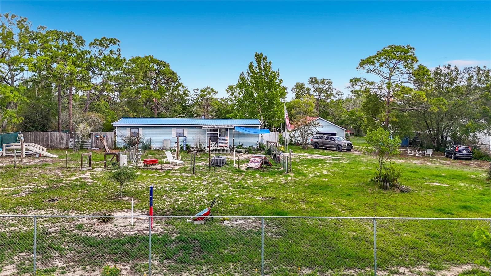 Welcome to your new Florida oasis, with over an acres of completely fenced-in land, and multiple outbuildings. If you have been looking for an incredible homestead that is still close to modern conveniences, this home is perfect for you! The home is spacious, with over 1,200 square feet of living space, plus a huge garage / barn, greenhouse, back deck, chicken coop, and additional fencing for livestock, such as goats or even a horse! Stepping into the front door, you'll enter the living room, complete with fireplace! The kitchen and dining rooms are off to the east side of the home, and the bedrooms and bathrooms are to the west. The master suite takes up a huge portion of the home and is incredibly spacious, with ensuite bathroom! Live in the country while still being less than 10 minutes away from Publix and the Suncoast Parkway! The house also has a fire hydrant out front, saving a ton of money on property insurance! This home has great bones and layout, and with a buyer's touch, is the perfect homestead!