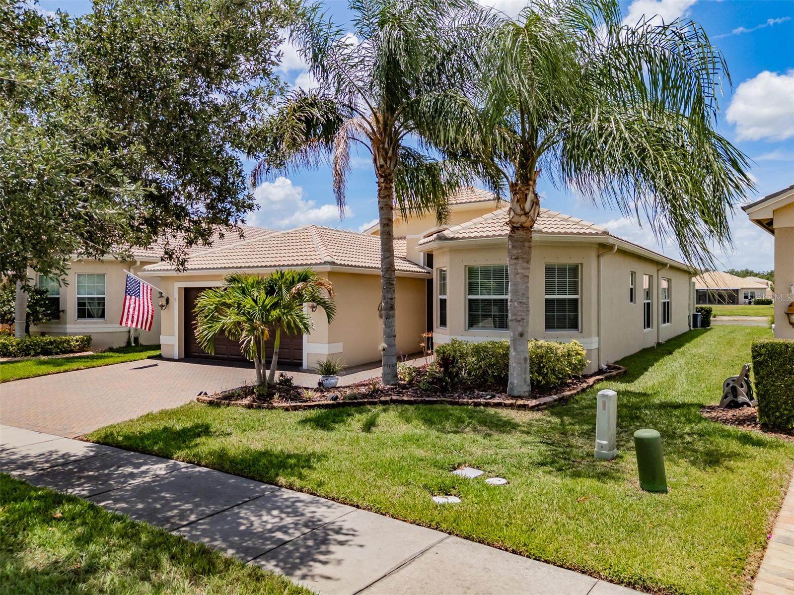 Situated on a cul-de-sac with peaceful westerly lake views, in Valencia Lakes, Tampa Bay’s premier 55+ Active Adult community, this gorgeous ROMA model offers 2,420SF of beautifully upgraded living space. This ROMA features 3 bedrooms plus an Office, 3 Bathrooms, Family Room, Living Room, Dining Room, Breakfast Bay, Kitchen, a 400SF Screen Room and a 24’x 20’ oversized Garage. Freshly painted within, this ROMA is move-in ready. The 18’ long Foyer has a 13’-14’ tray ceiling with three Z-LITE Burst chandeliers. Stunning! Crown molding and 51/2” baseboards, ceiling fans, quartz counters, and framed ‘to the ceiling’ mirrors, run throughout. The Kitchen features solid wood espresso-colored, soft-close cabinetry with sliding shelves and a Lazy-Suzy, natural stone backsplash, two Pantries, two glass-front upper cabinets, a built-in desk, LG Studio SS appliances, a Frigidaire EVEN-TEMP fridge, and an island with a single basin sink with an RO faucet. The Breakfast Bay has bespoke benches with storage and a 5-panel Bay window overlooking the lake. The Dining Room will comfortably seat 10 persons and features a spectacular 21-globe cluster chandelier. Adjacent to the Dining Room is the Living Room, … how might you use this delightful space? The Family Room features two floor outlets enabling furniture flexibility and a 4-panel 10’ center-opening sliding glass door with powered shades overlooking the Screen Room and the lake. The Primary Suite has a 10’-11’octagonal tray ceiling, a 3-panel bay window overlooking the lake that provides magnificent sunset views, lanai access via a full-length glass door with enclosed sliding louvres, two walk-in closets (closets throughout feature custom cabinetry & shelving), and a luxurious Ensuite Bathroom with two separated vanities, a jetted garden tub, glassed walk-in shower, and a Water Closet for the commode. Bedroom 2 features a 3-panel bay window and is at the front of the home affording guests outstanding comfort and privacy. Bedroom 3 is centrally situated in the home and features a stunning wall unit with a Murphy bed and 10’ wide closet. The Office has double French glass doors and a large 6’x6’ window. Bathroom 2 has tub-to-ceiling tile, and Bathroom 3 has a glassed walk-in shower. The Laundry Room features an LG washer & dryer on pedestals, upper cabinets, and a cabinet utility sink. The 24’x20’ oversized garage has luxury epoxy floors, abundant storage cabinets, two 4’x8’overhead Safe-T-Racks, a belt-drive Lift Master opener with MyQ and battery backup, a 71-gallon Rheem Marathon hot water tank, Culligan Iron Soft Plus water softening system, Eaton whole-home surge protector, insulated garage door, and a Magic Chef garage refrigerator. Who could ask for anything more? Valencia Lakes amenities include a 40,000SF Clubhouse, Resort-style pool, 5-Lane Lap pool, Resistance Pool, Spa, Steam Rooms, Saunas, on-site Masseuse, 6 USTA Har-Tru Clay Tennis courts, 7 Pickleball courts, Bocce & Shuffleboard lanes, the area's best softball field, a 5,000SF Fitness Center, and myriad Clubs & Social activities. Lawn care/irrigation, cable/premium channels, internet, ADT Home security are all included, so you never have to worry about a thing. Shopping, dining, & world-class medical services, Gulf-cost beaches, Tampa International Airport, Cruise Ports, Tampa, St. Petersburg, and Sarasota are all within 45 minutes. It’s resort-style living without compromise. This is more than a home — it’s a lifestyle. Seize the day.