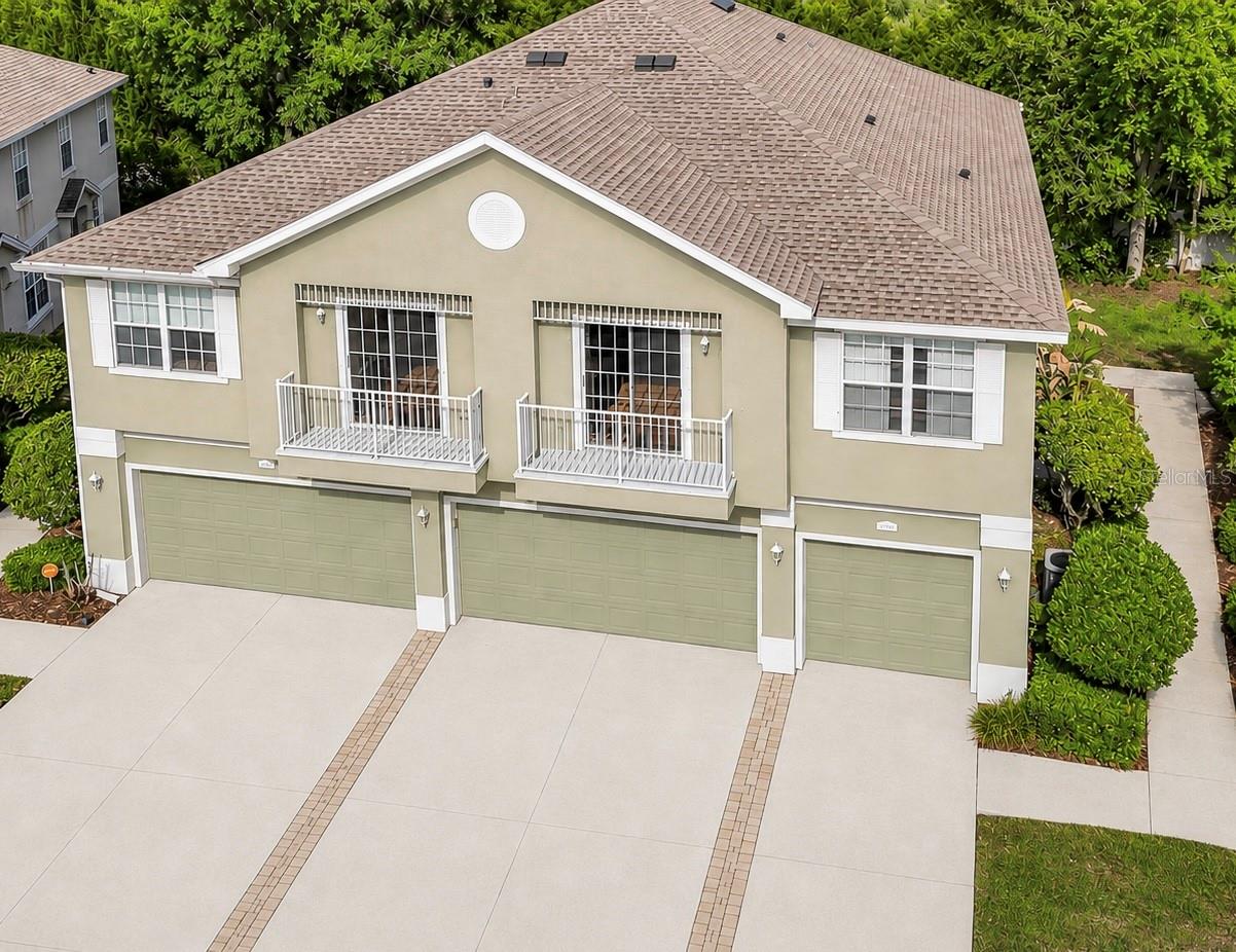 Tucked inside a gated, loop-style community, this corner-unit townhouse with a single-car garage delivers the perfect blend of low-maintenance living, cozy community feel, and affordability that’s becoming harder to find. Guest parking is directly out front for ultimate convenience, with the community pool only a few steps away. Inside, the main living area opens up with soaring ceilings and an abundance of natural light, pouring in through oversized sliding glass doors that lead to a private balcony. The living and dining areas flow seamlessly into the kitchen, where you’ll find ample cabinetry, generous counter space, and a breakfast bar that keeps everything connected. There’s even a built-in desk/workstation, ideal for working from home or staying organized without sacrificing space. The primary suite is spacious and comfortable, with an ensuite bath that includes dual sinks and a functional layout. The second bedroom is also well-sized, offering flexibility for guests, an office, or additional living space. The home is designed for everyday ease, featuring in-unit laundry and practical storage throughout. Enjoy low-maintenance living with added peace of mind. The HOA replaced the roof in 2024, taking care of one of the biggest expenses for you. Plus, water is included, making monthly budgeting that much easier. It’s the kind of setup that lets you spend less time worrying about upkeep and more time enjoying your home. Location truly sets this home apart. You’re just minutes from The Shops at Wiregrass and Tampa Premium Outlets** for top-tier shopping, dining, and entertainment, along with KRATE at the Grove, a local favorite for food, events, and unique vendors. With quick access to I-75, commuting into Tampa is easy, and you’re surrounded by nearby parks, walking trails, and everyday essentials. From weekend plans to daily errands, everything you need is conveniently close to home.