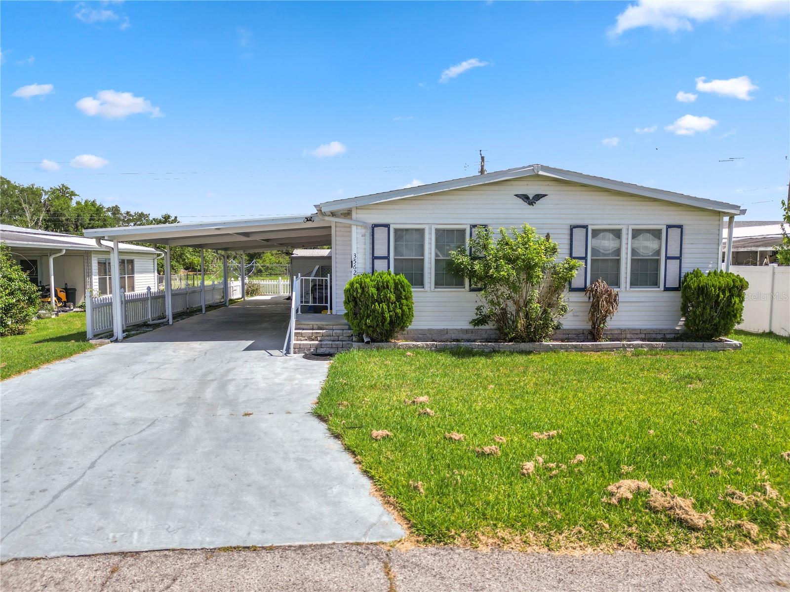 Welcome home to this well maintained 3 bedroom, 2 bath mobile home located in a peaceful and quiet community. Inside, you'll find tile flooring in the kitchen and bathrooms for easy maintenance, while the living area and bedrooms feature comfortable carpeting. Recent upgrades include newer windows and rain gutters, adding both value and functionality.

The spacious Florida room provides the perfect place to relax, entertain, or enjoy your morning coffee while taking in beautiful lake views. A Toshiba portable air conditioning unit helps keep the Florida room comfortable year round. Outside, you'll appreciate the vinyl picket fence in the backyard, creating an inviting space for pets, gardening, or outdoor enjoyment. The covered carport features a built in handicap accessible ramp, offering added convenience and accessibility.

Whether you're looking for a primary residence, seasonal retreat, or investment opportunity, this home offers comfort, accessibility, and scenic waterfront living in a tranquil setting. Schedule your private showing today!