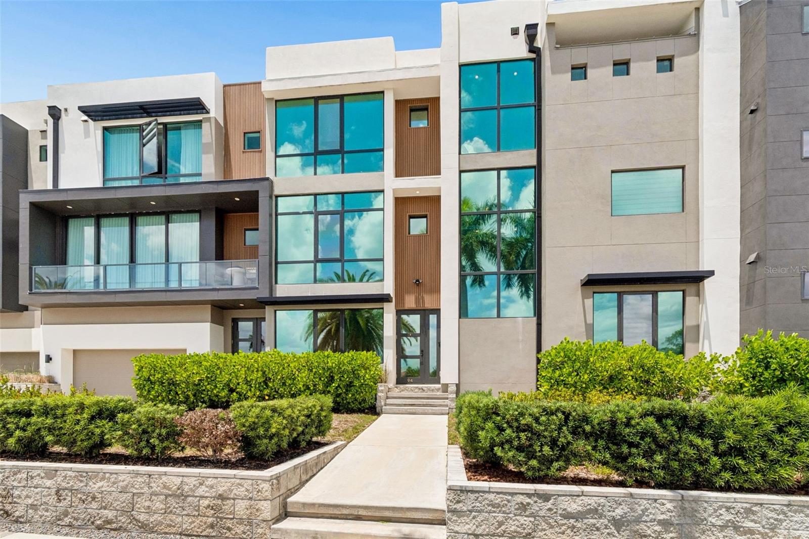 Ultra-luxury Davis Islands townhome designed by renowned architect Thomas Everett Lamb. Offering almost 4,000 square feet across three thoughtfully designed levels, this rare residence presents a unique opportunity to own one of the most upscale townhomes ever built in the Tampa Bay area.  No two residences are alike, and this exceptional unit features a spacious 4-bedroom, 4.5-bath floor plan, private ELEVATOR, oversized two-car garage with room for a golf cart and the ability to accommodate a lift for up to four cars, private entrances, and expansive open living spaces ideal for both grand entertaining and everyday luxury. Soaring 10-foot ceilings, walls of floor-to-ceiling insulated impact glass, and full-height windows fill every level with natural light, while a dramatic glass atrium with lush greenery brings a serene indoor-outdoor element to the home.  Designed with premium appointments throughout, the residence showcases pristine white European oak hardwood flooring, Sub-Zero and Wolf appliances, European-style custom cabinetry by Busby, Kohler fixtures, Italian porcelain tile in the bathrooms and laundry areas, and a wine cellar shell for the collector. Built with exceptional quality, the block-constructed home includes cast-in-place beams and columns, energy-efficient air conditioning systems with Wi-Fi integration, CAT5e wiring for ceiling access points on each level, and a water conditioning loop for a whole-house filter and water softener.  Multiple balconies and a spectacular private ROOFTOP TERRACE create an extraordinary outdoor living experience, offering panoramic views of Davis Islands and beautiful east and west water views. From morning coffee to sunset entertaining, the rooftop deck provides a stunning backdrop for enjoying Tampa’s coveted island lifestyle.