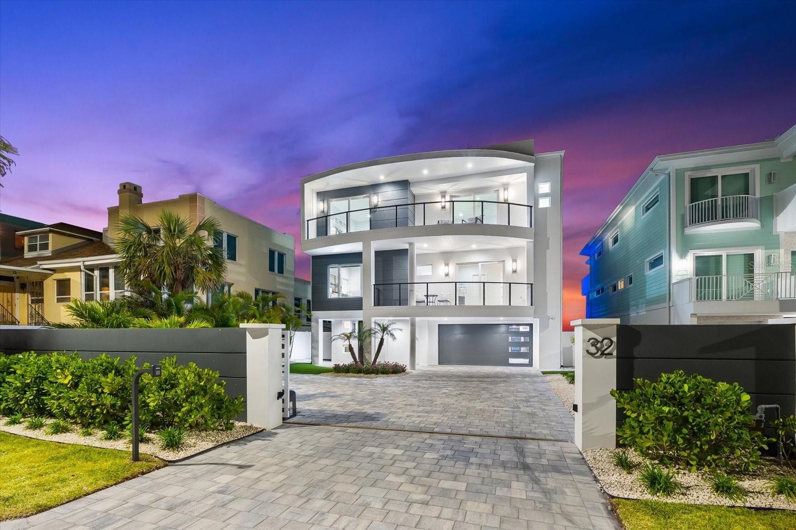 Where the Gulf meets grandeur—welcome to 32 Gulf Blvd, a rare gated beachfront estate that elevates every expectation. Perfectly positioned on the sugar-white sands of Indian Rocks Beach with breathtaking sunsets and unobstructed panoramic Gulf of Mexico views - a private dock with 20,000 lb boat lift along the Intracoastal Waterway, this architectural masterpiece offers an extraordinary dual-frontage lifestyle that is simply unmatched on Florida’s Gulf Coast. No need to wait to build when you can have new construction today! Crafted with the highest attention to detail, this custom-designed modern residence blends striking coastal design with timeless elegance across more than 9,400 square feet of seamless indoor-outdoor living. Floor-to-ceiling glass captures showstopping water views from every room, while the open-concept layout flows effortlessly from refined entertaining spaces to serene personal retreats. This spacious 5 bedroom masterpiece includes 5 full en-suite baths plus a powder bath, heated pool with covered sundeck, custom finished elevator, with an oversized 6-car garage. The exquisite gourmet kitchen is a statement of form and function—boasts dual designer selected luxury marble waterfall islands with full height marble backsplash, top of the line appliances including but not limited to Dacor refrigerator and freezer, double oven, microwave drawer, beverage center and 2 Fisher Paykel dishwashers. A separate bar with sink, French door wine fridge and beverage center with ice maker completes this perfect hub for entertaining. Walk-in pantry includes a washer and dryer closet. The open concept floor plan features an oversized great room spotlighting a 100-inch linear Modern Flames fireplace, LED cove ceiling lighting, opening onto expansive Gulf-facing terraces designed for sun-soaked afternoons and golden-hour evenings. The majestic primary suite is a sanctuary in every sense, boasts panoramic beach views, featuring a private waterfront sitting room, private coffee bar with sink and beverage center, dual boutique-style closets, an exquisite spa-like bath complete with floating solid wood vanities, spacious custom shower, elegant soaking tub creating a luxury spa inspired feel. Outdoors enjoy 5 waterfront verandas and balconies offer panoramic sunrise and sunset views, lush tropical landscaping, a custom designed Pebble Tec pool and spa with sun shelf and custom LED lighting and water features invites relaxation beneath the palms. Behind the scenes, uncompromising quality shines: a whole-house generator, custom elevator, open-cell foam insulation, dual laundry rooms, and a six-car garage complete this meticulously engineered residence. Built to V standards, a favorable AE zone designation for low flood insurance rates, private entry gate, designer finishes and ultra high-end appointments make this home completely unique and the ultimate beachfront retreat. This is not just a home—it’s a landmark. A statement of luxury, design, and lifestyle for the discerning buyer. Schedule your private showing today and step into a level of beachfront living few will ever experience.