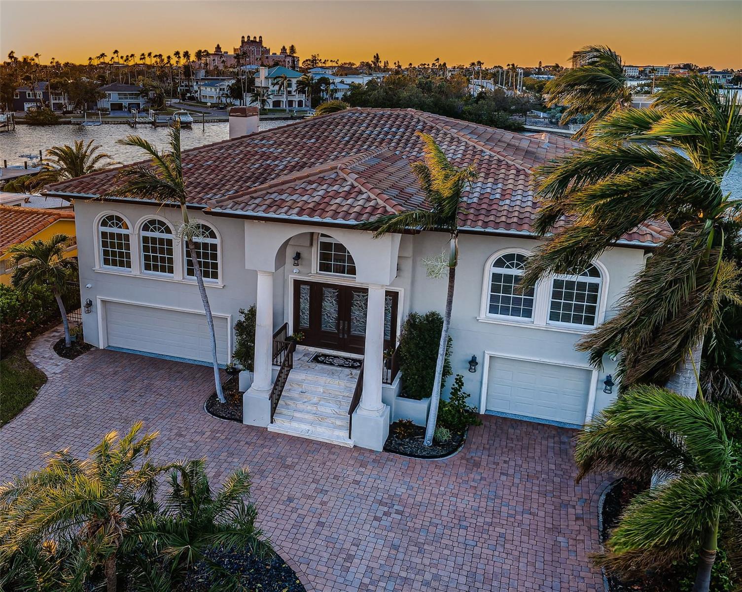 MOVE-IN READY WITH ALL CONCRETE CONSTRUCTION AND UPDATED TO THE LATEST WINDSTORM CODES - NO FLOOD DAMAGE AND NO HURRICANE DAMAGE! Flood insurance is under $600 per year.  Installed in 2022, the seawall has been purposefully elevated and rest high above the waterline.  Located in highly desirable Vina Del Mar, this elegant 4 bedroom, 3 bath luxury residence is beautifully-appointed with fabulous cast stone exterior finishes.  Beyond the fine brick paver circular driveway and impressive 19ft-high covered entryway, you’ll discover an exceptional estate residence with towering 12ft-high ceilings throughout, rich distressed designer tile flooring, lovely solid-core doors, striking cast stone columns, wide archways, automated window treatments, exquisite woodworking with tray/crown ceilings, and automated luxury designer lighting.  Formal sitting area transitions to a stunning gourmet kitchen with Subzero/Viking SS appliances, gas cooking, posh granite surfaces, custom Burl Walnut cabinetry, splendid island prep center and multi-level breakfast bar.  The large family room, offering big window views of your waterway and features a custom contemporary wood/marble fireplace and media wall.  Step into the gorgeous owner’s suite and be treated to sweeping westerly waterviews (and partial views of the Don Cesar in the background) with a large sitting area and access to the superbly-finished 200sqft covered waterfront balcony.  The owner’s bath is a pampering joy, with brilliant dual vanities, dedicated cosmetics center, dazzling jetted-spa tub, a deep walk-in shower with dual shower heads, and a fabulous walk-in closet with custom cherrywood closet system.  Bedrooms have a graceful appeal while the bathrooms exude a deeply-satisfying opulence and sophistication.  Facing your waterfront is a 38ft-wide, 370 sqft covered lower-level deck that transitions to sparkling Pebbletech pool and spa built in 2022, all supported by a large, 2022 shellstone paver deck.  Deep water TREX composite dock with newer 20,000lb boat lift and moorings for a 65ft yacht, offers access to the Gulf in just 10 minutes. Large lower-level multi-purpose storage/game/fitness space, 2-stop elevator, sizable indoor laundry with storage, whole-house water softening and filtration system, epoxy garage flooring, and so much more!  Interior has been freshly updated with paint and lighting in 2024.  A great, move-in ready, luxury value!
