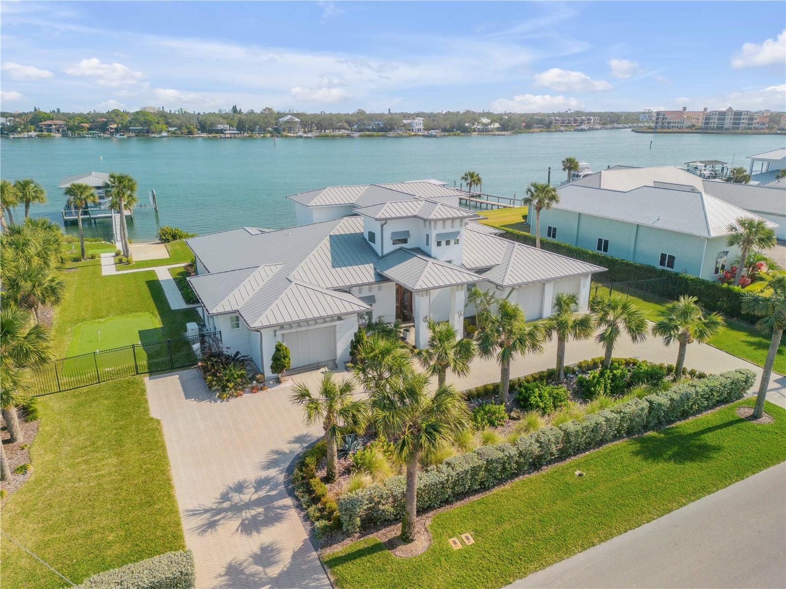 Check out the Matterport 3D tour! Welcome to your Custom Waterfront Dream Home. This exquisite waterfront property offers the perfect blend of luxury and comfort, designed with an open-concept layout that maximizes natural light and stunning water views. A spacious downstairs master suite serves as your personal retreat, complete with his-and-her walk-in closets and a massive spa-inspired bathroom featuring a large walk-in shower and a soaking tub. You'll never want to leave this serene sanctuary. In addition to the master suite, the home boasts three spacious guest bedroom suites, each offering ample space and privacy. An office, which can easily serve as a fifth bedroom, provides flexibility to suit your needs—whether for work, guests, or a quiet space of your own. The heart of the home is the beautifully appointed chef’s kitchen, complete with a generous island and top-of-the-line appliances, making it perfect for preparing meals and entertaining family and friends. The open-concept living area flows seamlessly, creating an inviting space that feels as though it’s part of the surrounding natural beauty. Step outside to your expansive covered porch, where you can fully embrace the salt life. With another large dining and living area, this space is ideal for relaxation and entertainment. Enjoy evenings bug-free, thanks to automatic screens, while taking in the serene surroundings. The saltwater pool offers refreshing views of the Intracoastal Waterway, and the outdoor shower and kitchen make alfresco living a breeze. The spacious yard features endless options for fun, including a bocce ball court, chipping area, and putting green. For boating enthusiasts, this property is a dream come true. Two separate docks, including a 25k-lb lift, a 12k-lb lift, and a private boat ramp/launch, provide unparalleled access to the water. Additional highlights include a ten-car driveway, three-car garages, a 22kW generator, and a commercial-grade ice maker. Located just a short walk, bike ride, or golf cart ride across the bridge to Flagler Ave’s vibrant shops and restaurants, as well as the world-renowned shores of New Smyrna Beach, this home offers a lifestyle like no other.