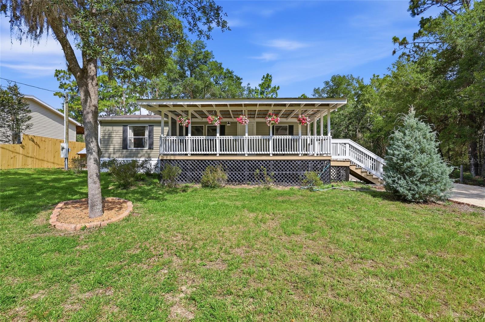 Virtually Staged. Come enjoy the peace and privacy of country living in this charming 2015 built 3-bed, 2-bath home in the Williston Highlands Golf & Country Club Estates. This home is truly move-in ready with a new HVAC, new well pump, freshly painted interior & exterior, upgraded landscaping, new fence, new crushed limestone driveway, and a shed with electricity and work table. Walk up the stairs to your spacious front porch, perfect for relaxing and appreciating the beautiful views of your quiet neighborhood. Inside, you’re greeted by an inviting living room complete with an electric fireplace and newer vinyl plank flooring that extends throughout most of the home. The open-concept layout flows into the thoughtfully updated kitchen, which features upper and lower cabinetry, ample counter space for hosting family and friends, and a pantry for plenty of storage. Enjoy meals in the dining area just off the kitchen. The home features a split plan for the bedrooms, with the primary suite just off the living room. The primary bedroom has two closets and is accompanied by an en-suite bathroom complete with a stylish vanity and walk-in shower. The two guest bedrooms are on the other side of the home with a hall bathroom that features a tub-shower combo. The convenient laundry area includes upper cabinets for additional storage. Step onto a sprawling back porch that overlooks your spacious fully-fenced backyard with new landscaping and a storage shed ideal for gardening tools, outdoor gear, and extra storage needs. The home also comes with a propane-powered generator for peace of mind. The new limestone driveway can accommodate multiple cars along with RV parking. The 0.23 acre adjacent vacant lot behind is included in the sale (parcel 0918701800), making this almost a half acre of privacy! Schedule your showing today!