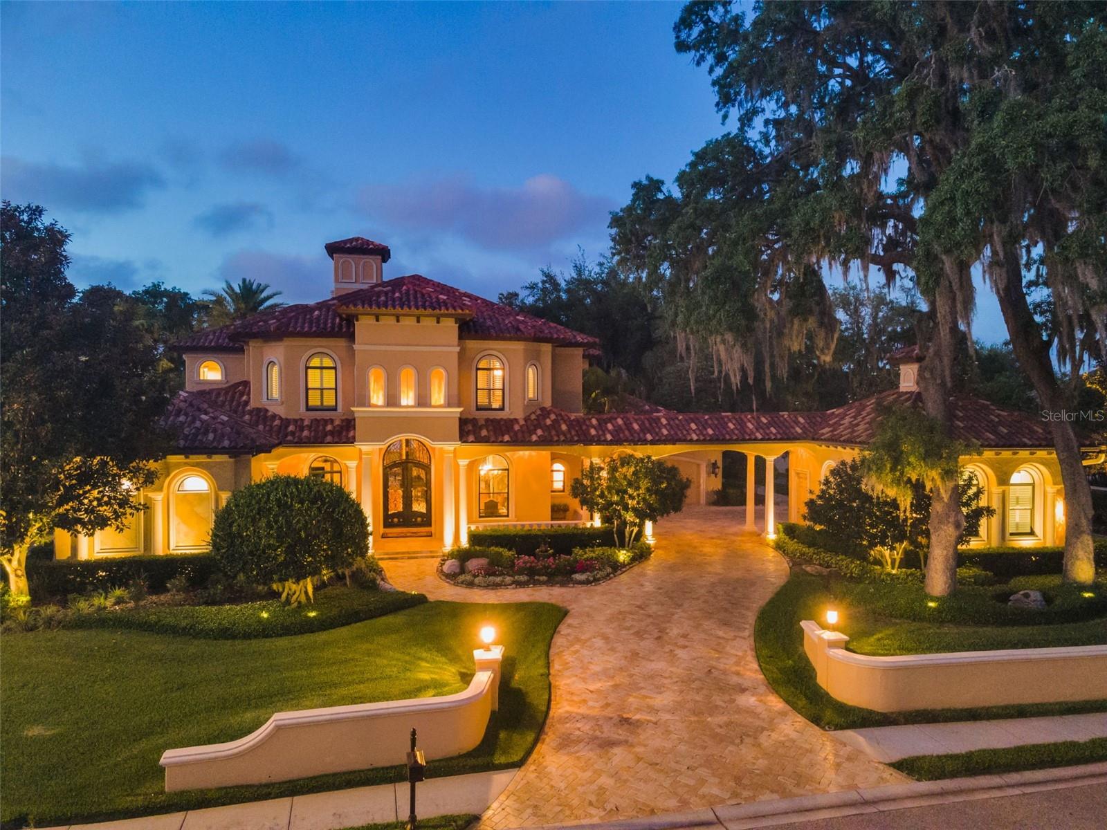 Welcome to an extraordinary offering in the gated enclave of Champions Club, one of Tampa Bay’s premier luxury communities surrounding the renowned Fox Hollow Golf Course. Perfectly positioned just off the 2nd fairway, this magnificent Mediterranean-style estate by Campagna Homes showcases nearly 6,400 SF of living space, masterfully designed with custom upgrades and the finest finishes throughout. Surrounded by lush tropical landscape and breathtaking golf course and pond views, this home embodies the pinnacle of Florida luxury living. From the moment you arrive, the estate makes a lasting impression with its stunning curb appeal, elegant architectural details, and custom leaded glass entry doors. Inside sophisticated craftsmanship and timeless design elements blend seamlessly with inviting living spaces. Rich custom accents, designer lighting, intricate millwork, soaring ceilings, and refined finishes elevate every room, creating an atmosphere of understated elegance and grandeur. Designed with both entertaining and everyday luxury in mind, the gourmet chef’s kitchen is a true showpiece featuring premium Sub-Zero and Wolf appliances, striking copper hood and sinks, designer-grade custom cabinetry, expansive granite countertops, and an oversized center island ideal for gathering with family and guests. Whether hosting intimate dinners or large-scale celebrations, the kitchen flows effortlessly into the home’s spacious living and entertaining areas. A standout feature of the home is the spectacular billiard and game room complete with a custom full bar, creating the ultimate space for entertaining, relaxing, and hosting gatherings. The home’s thoughtfully designed layout also offers spacious secondary bedrooms, each featuring its own beautifully appointed ensuite bath, providing exceptional comfort and privacy. The luxurious first-floor owner’s retreat serves as a private sanctuary, complete with a spa-inspired bath featuring a jetted soaking tub, dual vanities, an oversized dual rain shower, and an expansive custom California walk-in closet. On the opposite wing of the home, a private suite with separate exterior entrance offers incredible versatility as a guest retreat, in-law suite, private lounge, or additional entertainment space. The suite also features an impressive custom theater with premium audio and video equipment and seating for 10, creating the ultimate movie-night experience. Step outside to your own private resort-style oasis where every detail was thoughtfully curated for relaxation and entertainment. The spectacular outdoor living space features a fully equipped outdoor kitchen, sparkling pool and spillover spa, dramatic rock waterfall with hidden waterslide, fire pit, and multiple gathering spaces designed for unforgettable Florida evenings. Whether enjoying brunch poolside, entertaining under the stars, or simply taking in the tranquil golf course setting, this backyard retreat rivals the finest luxury resorts. Located within the highly sought-after Champions Club community, residents enjoy access to world-class amenities including a private clubhouse, resort-style pool, tennis courts, fitness center, and a vibrant social atmosphere, all just minutes from top-rated schools, upscale dining and shopping, medical facilities, Tampa International Airport, and the Gulf Coast’s award-winning beaches. This exceptional estate is truly a rare opportunity to experience luxury living at its finest.