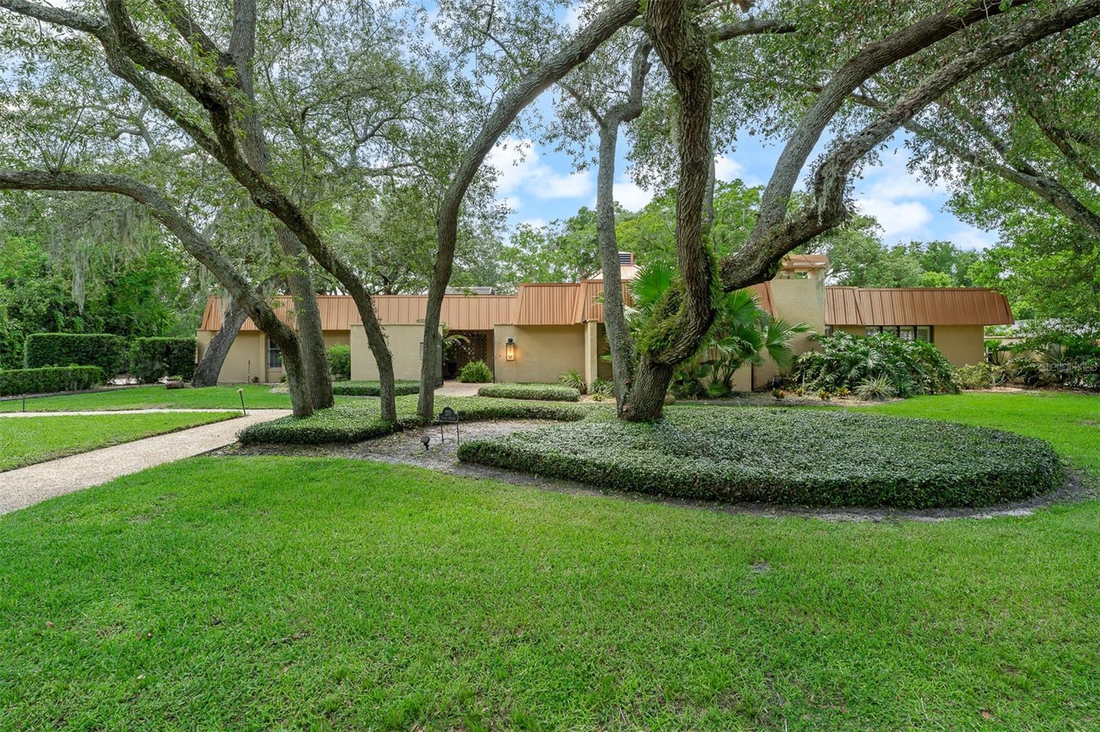Welcome to Hidden Estates, where luxury, space, and flexibility come together in one of Maitland's most sought-after neighborhoods. Nestled on a quiet cul-de-sac, this rare single-story custom residence offers over 4,000 square feet of thoughtfully designed living space on an expansive three-quarter-acre lot.  From the moment you arrive, you'll appreciate the impressive curb appeal, oversized driveway, and exceptional parking with plenty of room for multiple vehicles, boats, RVs, trailers, and recreational equipment.  Inside, the home's spacious open layout is designed for both everyday living and entertaining, featuring soaring ceilings, hardwood flooring, crown molding, skylights, custom built-ins, plantation shutters, and a wood-burning fireplace. At the center of the home is a beautifully appointed chef's kitchen with custom mahogany cabinetry, granite countertops, a Thermador refrigerator, six-burner gas cooktop, double ovens, an oversized island with bar seating, and a generous walk-in pantry.  The luxurious primary suite serves as a private retreat with its own sitting area, walk-in closet, heated bathroom floors, dual vanities, oversized walk-in shower, and freestanding soaking tub.  One of the home's most unique features is its flexible layout, including a private guest suite situated on the opposite side of the home and a separate office overlooking a tranquil atrium, offering endless possibilities for guests, multigenerational living, a home office, or creative space.  Step outside to your own private backyard oasis featuring a screened saltwater pool and spa with waterfall, an expansive covered lanai, and abundant outdoor living space designed for year-round Florida enjoyment. The oversized lot provides exceptional privacy while offering ample room to relax, entertain, or personalize the outdoor space.  Additional highlights include a metal roof with copper fascia (2018), new septic drain field, and an unbeatable Maitland location convenient to shopping, dining, parks, major roadways, and everyday conveniences. This is a rare opportunity to experience the space, privacy, and versatility that define luxury living in Maitland.
