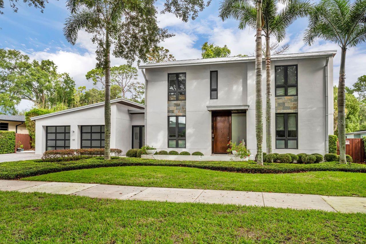 This one-of-a-kind, top-tier custom contemporary home in coveted Beverly Shores/Rose Isle delivers true turnkey luxury with exceptional finishes, premium cabinetry, high-end appliances, and fully integrated smart features throughout.  The six-bedroom, three-and-a-half-bath main home—featuring one bedroom currently used as a private office—plus a detached 384 SF casita (seventh bedroom) sits on a premium lot with access to scenic Mead Garden—essentially an extension of your own backyard.  Sunlight fills the open, modern layout through oversized windows and twelve-foot retractable sliding doors.  Polished concrete floors and solid cement construction provide strength, energy efficiency, and impressive sound control.  The gourmet kitchen boasts Viking stainless steel appliances (including refrigerator and separate freezer), espresso cabinetry, a waterfall island, walk-in pantry with washer/dryer, and Caesarstone countertops.  The kitchen, dining, and great room flow seamlessly around a custom media center.  A glass-enclosed wine room displays your collection with gallery-like elegance, offering storage for 56 bottles and a dedicated wine and beverage refrigerator.  The main level also includes a bedroom with en-suite bath and a sleek office with built-ins.  Four massive sliding doors open the entire space to the resort-style heated saltwater lap pool and spa, all controlled by a wireless panel.  The outdoor living area features a full summer kitchen with gas grill and burners, Viking beverage fridge, ice maker, retractable awning, TV, and automatic mosquito screen—an all-season extension of the home.  Upstairs, the primary suite offers a peaceful retreat with a walk-in closets, Caesarstone dual vanities, soaking tub, walk-in shower with ceiling-mounted showerhead, and a private balcony overlooking the pool and Mead Garden.  Two additional bedrooms share a Jack-and-Jill bath, and a flexible bonus room serves as a media room, gym, or nursery.  A secondary washer and dryer add convenience.  The detached casita functions as its own private getaway with four sliding doors, kitchenette, half bath, and outdoor shower—perfect for guests or poolside days.  An oversized 1,000 SF garage accommodates up to four cars or a remarkable workshop.  A rare blend of boutique luxury, modern design, and effortless indoor–outdoor living, this truly turnkey property offers resort-style comfort steps from both Orlando and Winter Park—an exceptional lifestyle home in one of Central Florida’s most desirable locations.