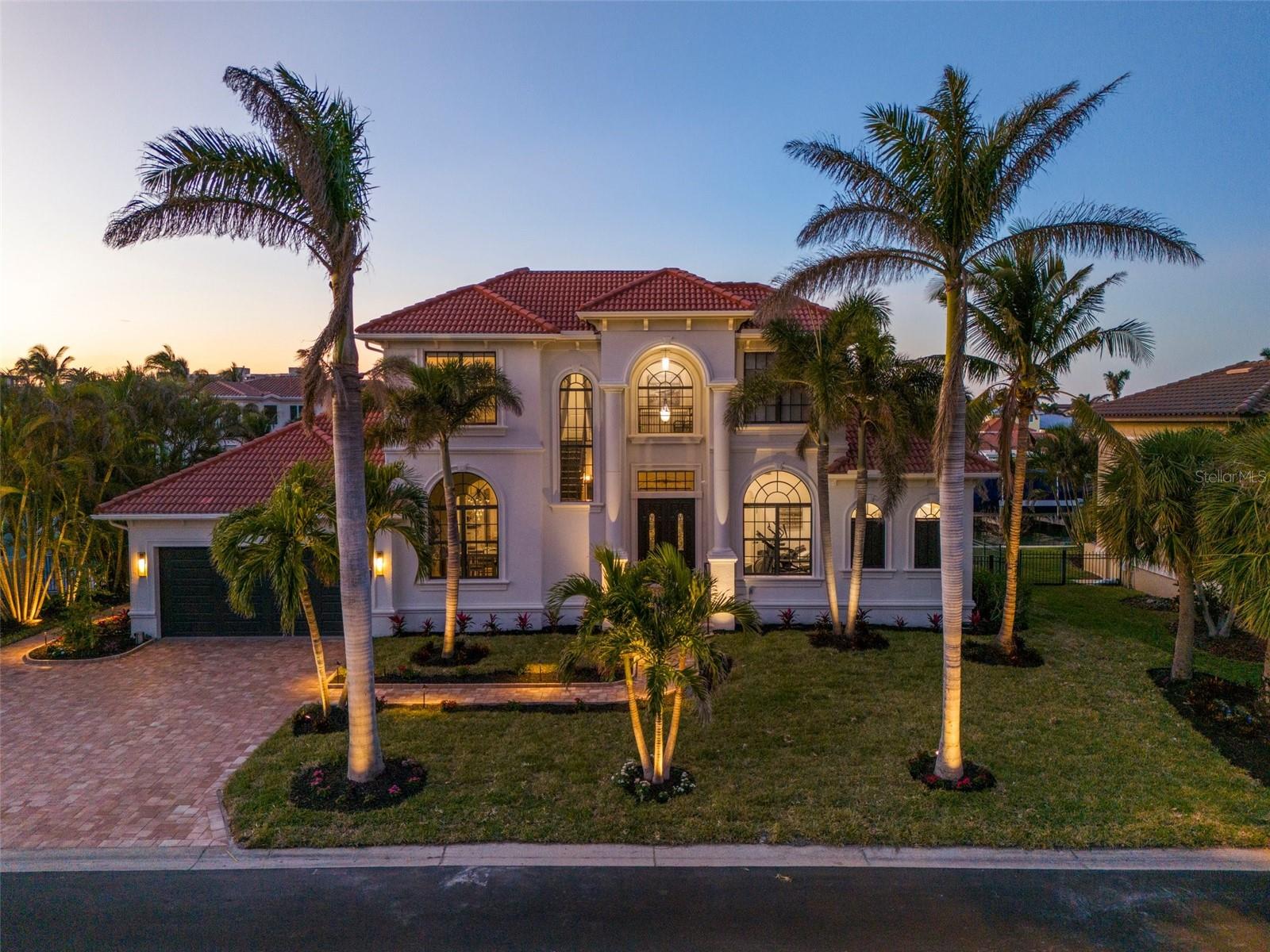 Nestled in the sought-after Country Club Shores on Longboat Key, this exquisite waterfront residence is your gateway to luxury living. This home provides direct BOAT ACCESS with a private DOCK and features DEEDED BEACH ACCESS for endless coastal adventures. This elegant Florida-friendly floor plan features a FIRST FLOOR MASTER suite and office, TWO spacious bedrooms on the second level, plus an IN-LAW SUITE for guests or extended family complete with a NEW FULL BATHROOM and secondary washer-dryer. There is nothing left for you to do other than move right in! The upper and lower terraces provide breathtaking views of the lush tropical pool and spa area, perfect for relaxing or entertaining. High-end finishes like QUARTZ countertops in the kitchen and bathrooms and NEW FLOORING elevate the interiors along with a cozy NEW fireplace, widescreen HDTV, and SONOS surround sound system to ensure comfort and entertainment for you. The chef's kitchen boasts a GAS range, ideal for culinary enthusiasts along with NEW APPLIANCES. MASTER BATHROOM remodeled beautifully. Enjoy your NEW BACKYARD and gas-powered fire bowls for endless entertainment. Formal and informal dining areas accommodate all occasions, while the luxurious master suite offers serene waterfront views with private balcony access. Keep your garage cool with the new 2024 air conditioning installed and stack your cars if you desire. Experience the ultimate home in Longboat Key where living every day feels like a vacation.