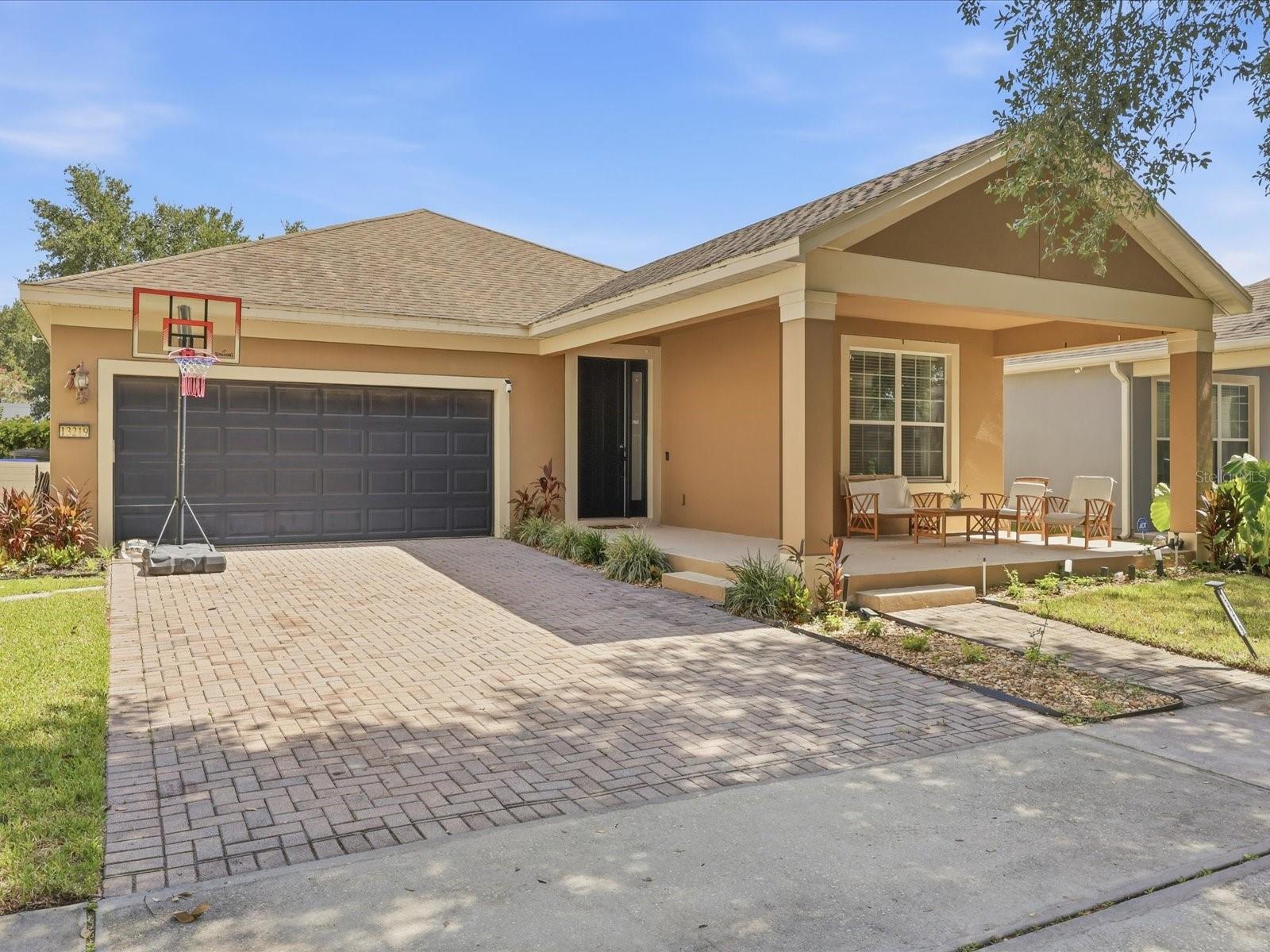 Welcome to this charming and inviting home nestled in the highly desirable Lake Sawyer South community in Windermere. As you drive through the neighborhood, you'll immediately appreciate the mature landscaping, beautiful tree-lined streets, and peaceful atmosphere that make this communityso special. Upon arrival, you're greeted by a spacious covered front porch — the perfect place to relax and enjoy the Florida lifestyle. Step inside to a welcoming, wide foyer that opens to a bright and airy living room featuring soaring ceilings and an abundance of natural light. Two secondary bedrooms are thoughtfully positioned at the front of the home, offering privacy and flexibility for family members, guests, or a home office. The formal dining room is enhanced by a large window that fills the space with beautiful natural light, creating an inviting setting for entertaining. The open-concept kitchen overlooks the living room, making it ideal for gathering with family and friends. It also includes a cozy breakfast nook, perfect for casual everyday meals. Privately located at the rear of the home, the spacious primary suite is filled with natural light from three large windows. The en-suite bathroom features dual vanities, a soaking tub, a separate walk-in shower, a walk-in closet, and an additional linen closet for extra storage. Sliding glass doors from the living room lead to a covered  and screened lanai and a fenced backyard with a paved patio, providing the perfect space for outdoor dining, entertaining, or simply unwinding. Offering 1,706 square feet of living space, this well-maintained home features 3 bedrooms, 2 bathrooms, a formal dining room, an open living room, a functional kitchen, a dedicated laundry room, and a two-car garage. Conveniently located just minutes from Publix, coffee shops, dinners, restaurants, shopping, personal storage facilities, and schools. This home combines comfort, convenience, and an exceptional Windermere location. Don't miss the opportunity to make this beautiful and welcoming home your own—schedule your private showing today!  The existing solar panel financing is transferable to qualified buyers, offering the opportunity to enjoy energy savings without the upfront installation cost.