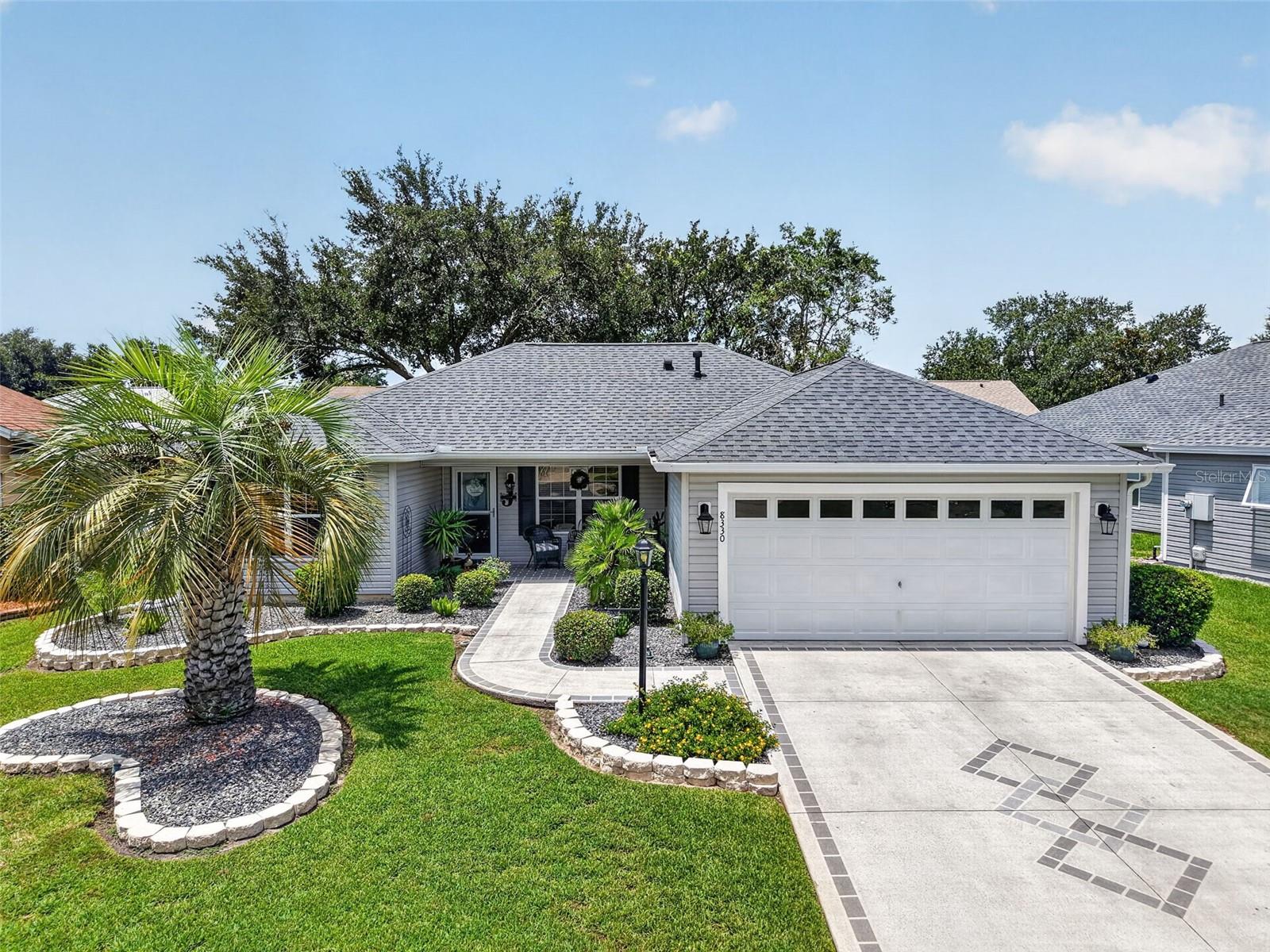 BOND PAID! This beautifully maintained Banyan Designer model (also known as the Bougainvillea) is ideally located on a cul-de-sac lot in the desirable Village of Briar Meadow. From the moment you arrive, you'll appreciate the exceptional curb appeal featuring stone curbing, 3 stunning palm trees, rock landscaping, a painted driveway and walkway, and a welcoming covered front porch with a glass storm door. Step inside to an inviting open floor plan enhanced by ENGINEERED HARDWOOD, vaulted ceilings, and abundant natural light. The spacious living and dining areas flow seamlessly into one another, with sliding glass doors opening onto the screened lanai, an ideal spot to relax or entertain while enjoying the privacy afforded by mature landscaping. Just beyond, a separate grilling patio offers additional outdoor living space with plenty of room for seating and gatherings. The beautifully updated kitchen is designed for both style and function, showcasing GRANITE countertops, a tiled backsplash, white cabinetry with convenient pull-out shelving, a GAS range, and a window over the sink overlooking the backyard. The adjacent laundry room provides additional storage and convenience. The generous primary suite offers a large walk-in closet and an updated en-suite bath featuring tile flooring, dual sinks with a GRANITE-topped comfort-height vanity, and a walk-in shower with upgraded river rock flooring. Two spacious guest bedrooms, each with double-door closets, provide comfortable accommodations for family and friends. The guest bathroom has also been updated with a granite countertop and a tub/shower combination with a glass door. Additional updates include a ROOF 2023, HVAC 2019, and a TANKLESS WATER HEATER, providing peace of mind for years to come. Conveniently located just a short golf cart ride from Springdale Pool, Mulberry Grove Pool, and Regional Recreation Center, the Dog Park, Nancy Lopez Legacy Country Club, the new First Responders Regional Recreation Center, and the Mulberry Grove Shopping Center with grocery, banking, pharmacy, medical offices, the VA Clinic, and numerous restaurants. You'll also enjoy easy access to championship golf courses, entertainment at Savannah Center, dining at Nancy Lopez Legacy and Glenview Country Clubs, and the US-441/27 corridor for additional shopping, dining, and healthcare. Come see why this should be your next new home!