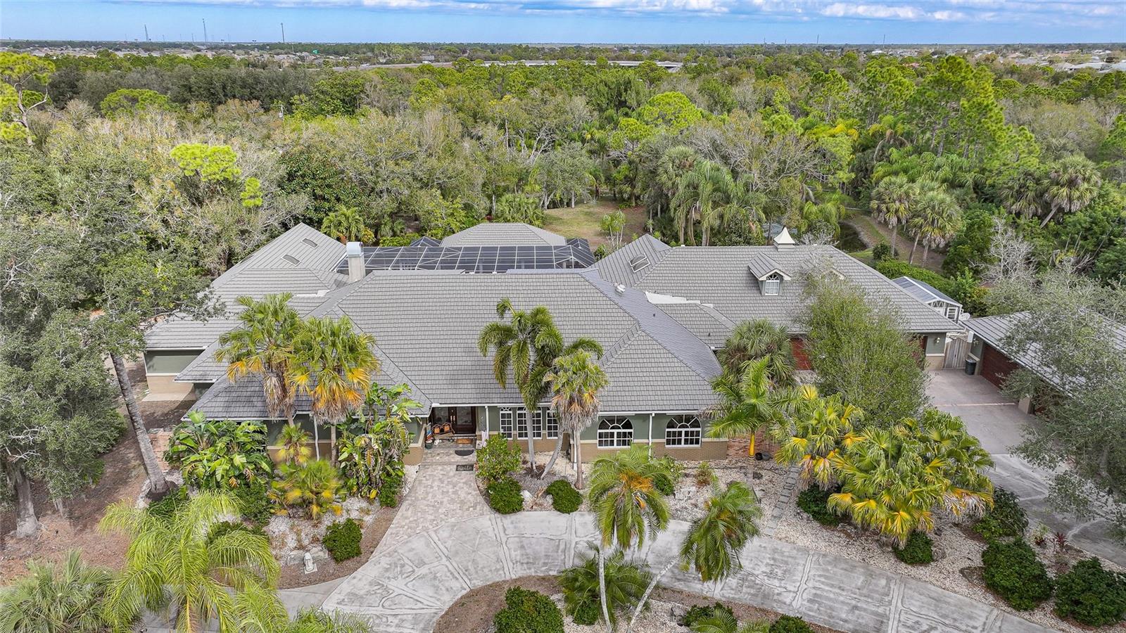 A Rare Hidden Estate of Unmatched Scale, Privacy, and Presence

Tucked quietly behind the rhythm of everyday life, yet moments from the heart of Port Charlotte and Punta Gorda, 24646 Tangerine Avenue is a world entirely its own. This extraordinary country estate delivers over 8,000 square feet of refined interior living, blending grand architecture, resort-level amenities, and total seclusion into a singular offering seldom found in Southwest Florida.

Beyond the gated entrance lies a property designed for those who demand both privacy and prominence. With six expansive bedrooms, four and a half baths, and an unrivaled 10-car garage capacity, this residence is as functional as it is impressive. A 2,400-square-foot BONUS building, attached AND detached garages with air conditioning opens the door to endless possibilities—collector storage, workshop, studio, or climate-controlled showroom.

The estate unfolds as a private retreat, curated for relaxation and large-scale entertaining alike. At its center, a 36’ x 18’ resort-style pool anchors an expansive outdoor living environment, complete with a dedicated pool cabana for guests and gatherings. For the ultimate owner’s escape, a separate 14’ x 22’ enclosed pool sits just off the primary suite, creating an intimate, spa-like sanctuary reserved for quiet moments and restorative living.

Natural beauty is woven seamlessly into the experience. A private pond spans the rear of the property, providing serene water views, a sense of depth, and a backdrop that feels worlds away from civilization—yet remains incredibly close to dining, boating, shopping, and beaches.

Every inch of this estate speaks to scale, intention, and versatility. Whether envisioned as a multigenerational residence, private compound, luxury retreat, or legacy property, this is a home that adapts effortlessly to elevated lifestyles.

Rarely does a property offer this level of square footage, acreage, privacy, garage capacity, and resort amenities—especially in such a central location.
24646 Tangerine Avenue is not simply a home; it is an estate designed to be experienced, remembered, and passed down.