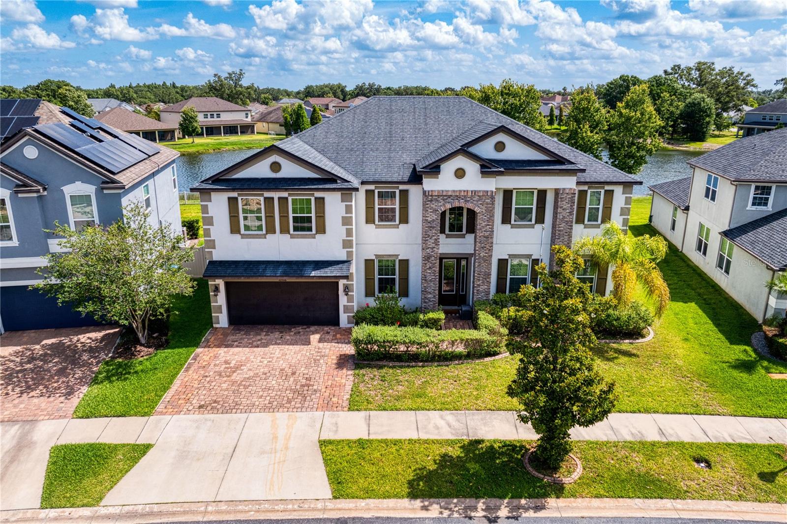 Poised within the highly desirable and gated Mariposa enclave of Riverview, this masterfully designed 7-bedroom, 4-bathroom (PLUS LOFT/BONUS ROOM, AND THEATER ROOM) contemporary estate stands as a distinguished sanctuary of scale and sophistication. The striking architectural facade—defined by high-gabled rooflines, smooth alabaster stucco, and a grand stacked-stone arched entryway—complements a 3-car garage and a meticulously landscaped waterfront homesite. Upon entry, a cinematic gallery foyer leads past a quiet executive workspace adorned with crown molding, elegant horizontal blinds, and grey wood-look tiled flooring, as well as a custom arched flex salon highlighted by integrated architectural shelving. At the heart of the main level, a luminous open-concept great room showcases a modern shiplap feature wall with an integrated linear electric fireplace, flowing seamlessly into an elegant dining space defined by a modern pendant light. The adjoining culinary stage is an epicurean masterpiece, anchored by a multi-purpose peninsula island with a breakfast bar, premium stainless steel appliances, pristine white shaker cabinetry, an optimized work triangle, a dedicated walk-in pantry, and a bespoke coffee bar. Completing this level is the private primary sanctuary, a tranquil haven featuring textured wood backdrops and sliding glass doors that open directly onto the waterfront lawn. The spa-inspired ensuite bath delivers an unparalleled wellness experience with its dual vanities, dedicated lower-profile makeup station, deep corner soaking tub, and a frameless glass shower adorned with decorative mosaic tile.

The residential luxury ascends to the second level, where a highly versatile floor plan reveals beautifully appointed bedrooms, a secondary laundry suite for ultimate convenience, and an expansive central recreational lounge designed for effortless leisure and organization. Each private bedroom throughout the estate is equipped with integrated ceiling fans, ensuring climate-controlled comfort and high-efficiency utility on both levels of the home. The seamless integration of indoor and outdoor living is realized through grand sliding glass doors that lead to a deep, wide covered patio supported by stately white pillars—an ideal setting for open-air dining and serene relaxation. Framed by an expansive backyard and tranquil water views, this high-performance residence effortlessly balances architectural grandeur with modern utility and strategic metropolitan connectivity. This extraordinary Mariposa estate delivers an unparalleled, move-in-ready lifestyle of coastal-inspired refinement without concession.  UPGRADES INCLUDE: NEW CARPET (2024) THROUGHOUT UPSTAIRS, INTERIOR PAINTING (2024), NEW AC UPSTAIRS (MAY 2025), NEW AC DOWNSTAIRS (OCTOBER 2025), NEW HOT WATER HEATERS (APRIL 2026), AND A NEW ELECTRIC FIREPLACE (2025).
